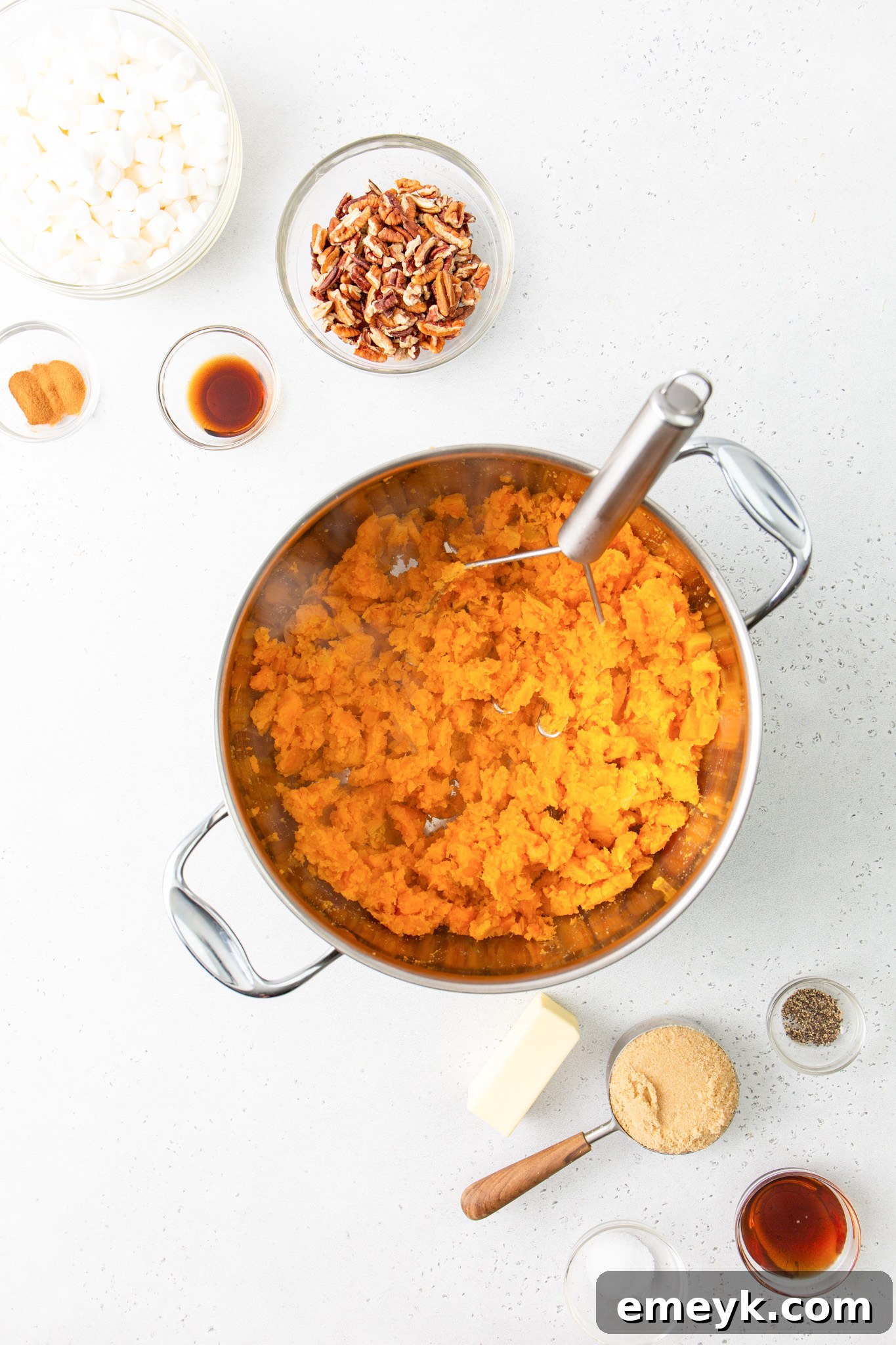 Sweet Potato Casserole with Marshmallows potatoes mashed in pot with a masher