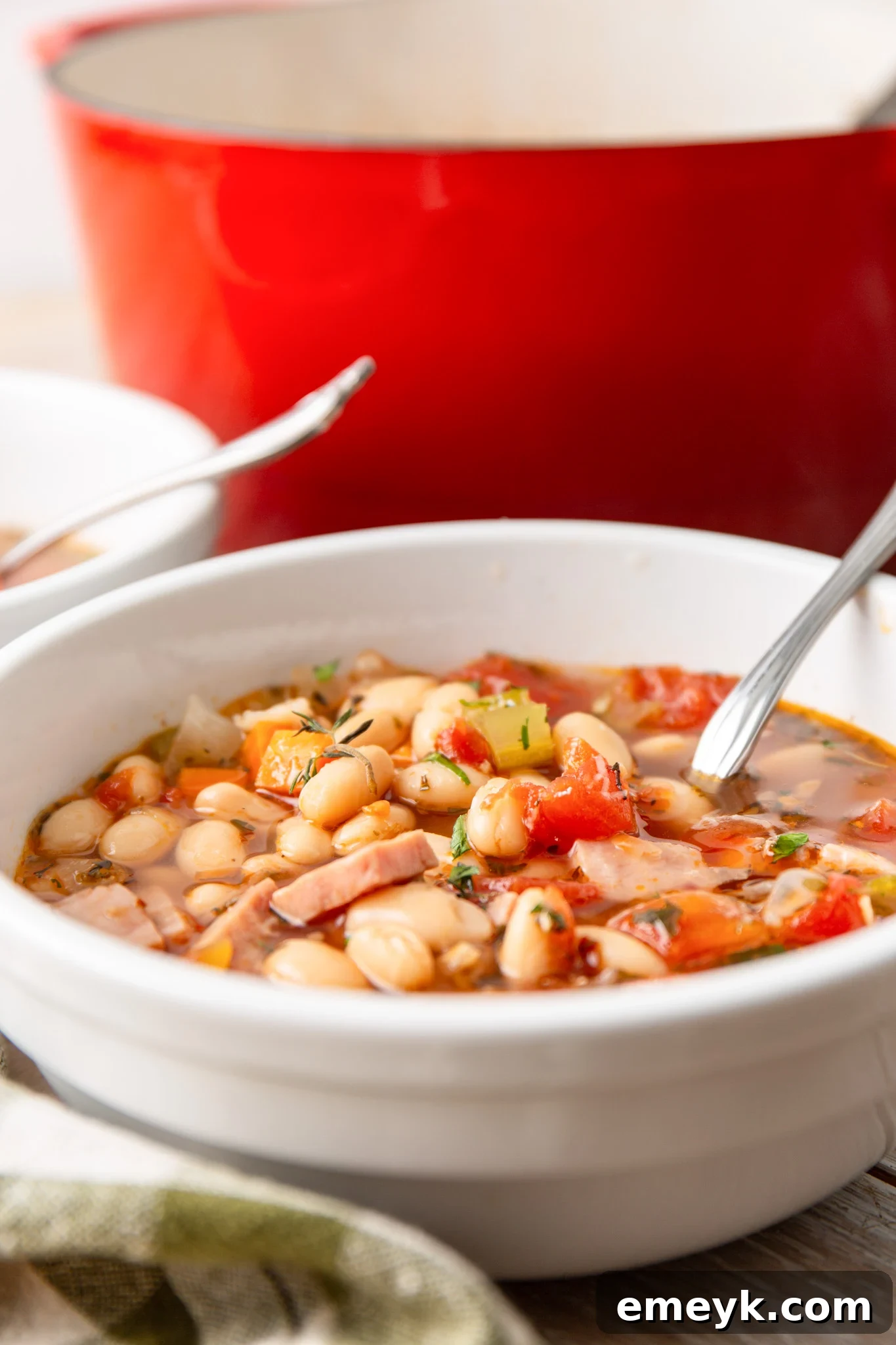 A large Dutch oven filled with simmering Navy Bean Soup, ready to be served.