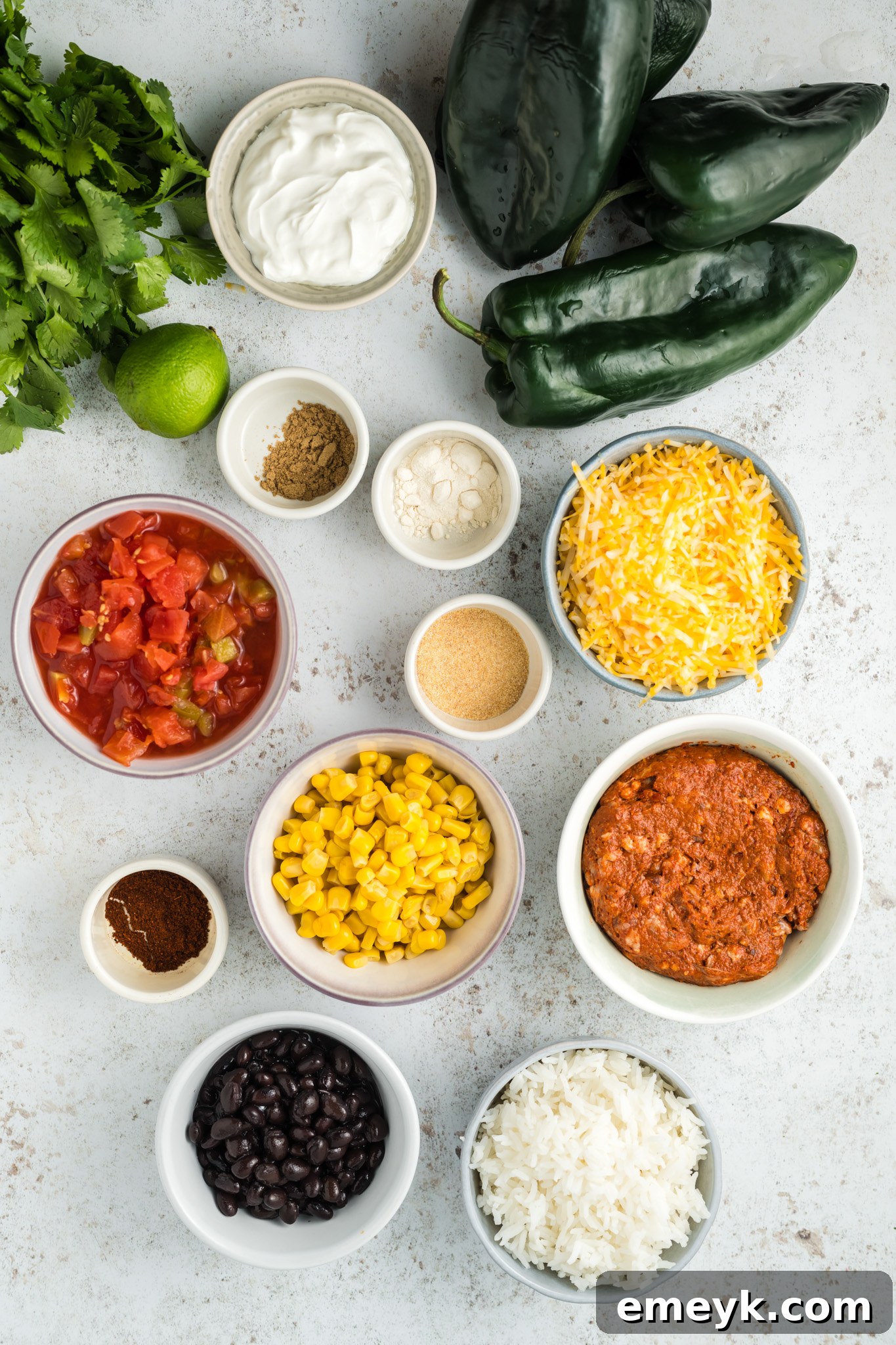 Fresh ingredients for Stuffed Poblano Peppers Recipe meticulously laid out on a clean wooden cutting board, including whole poblano peppers, uncooked chorizo, diced tomatoes, canned black beans, corn, and a vibrant array of spices.