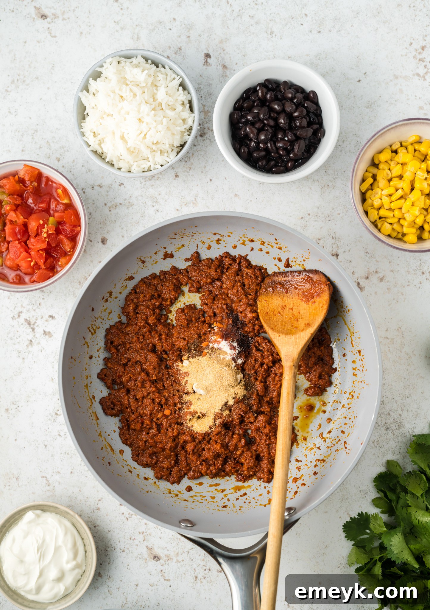 Sizzling chorizo cooking in a large cast-iron skillet with sautéed onions and garlic, creating a fragrant and delicious base for the Stuffed Poblano Peppers filling.