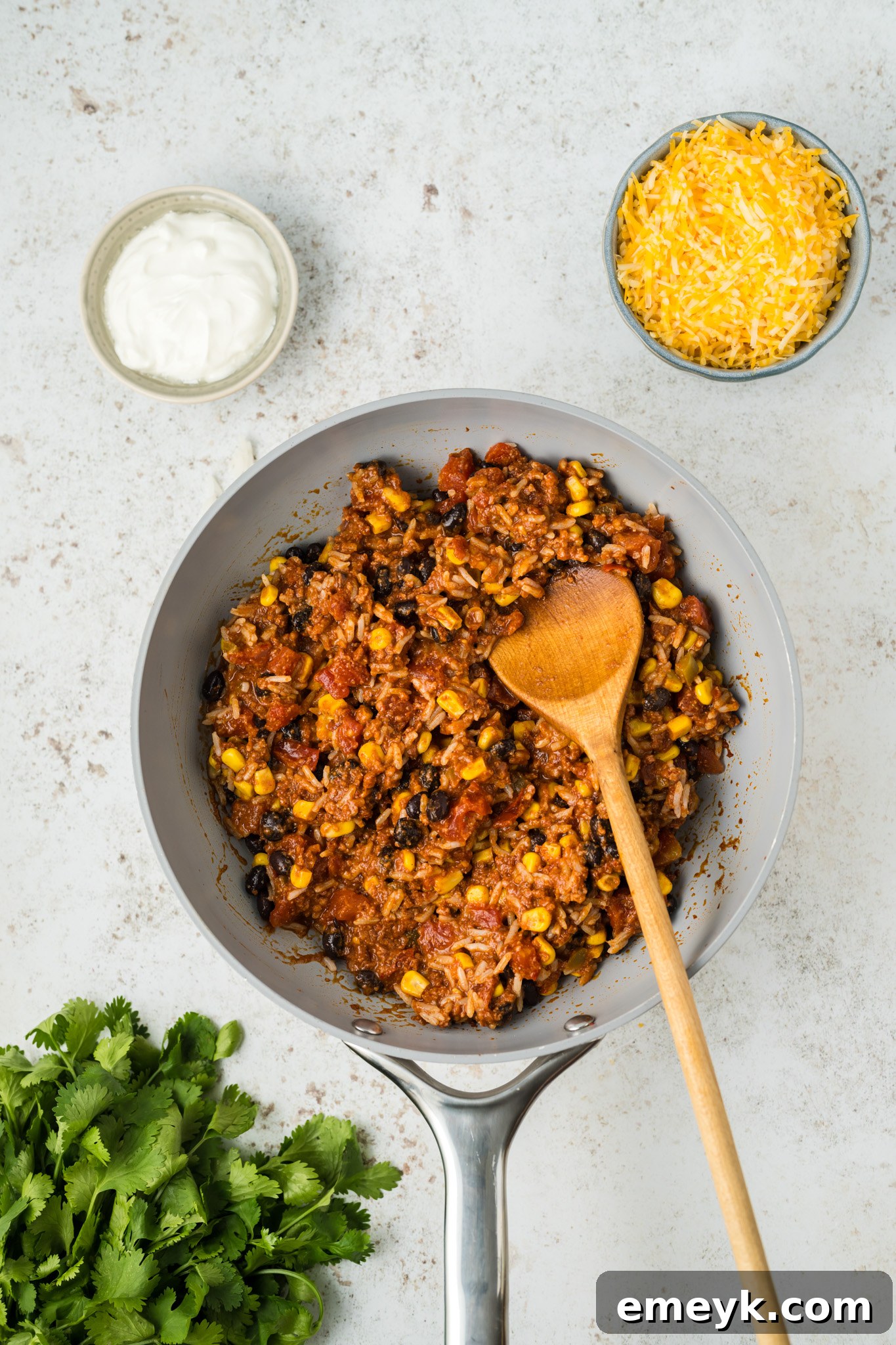 Close-up view of the rich chorizo, rice, black bean, and tomato mixture simmering in a skillet, showcasing its vibrant colors and delicious texture, ready to be used as a delicious stuffing for poblano peppers.