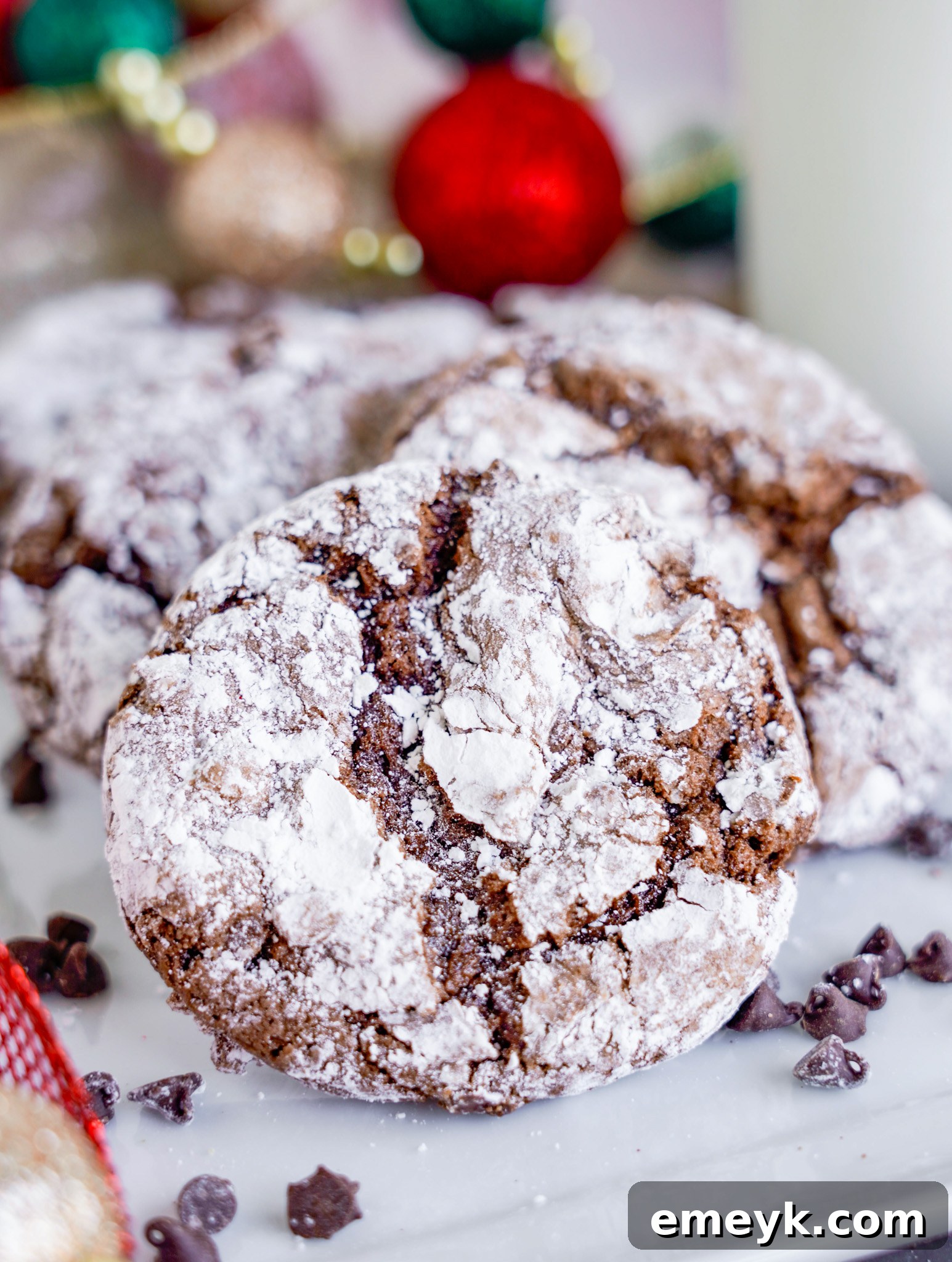 Delicious Chocolate Crinkle Cookies arranged on a white plate, showcasing their signature cracked powdered sugar coating.