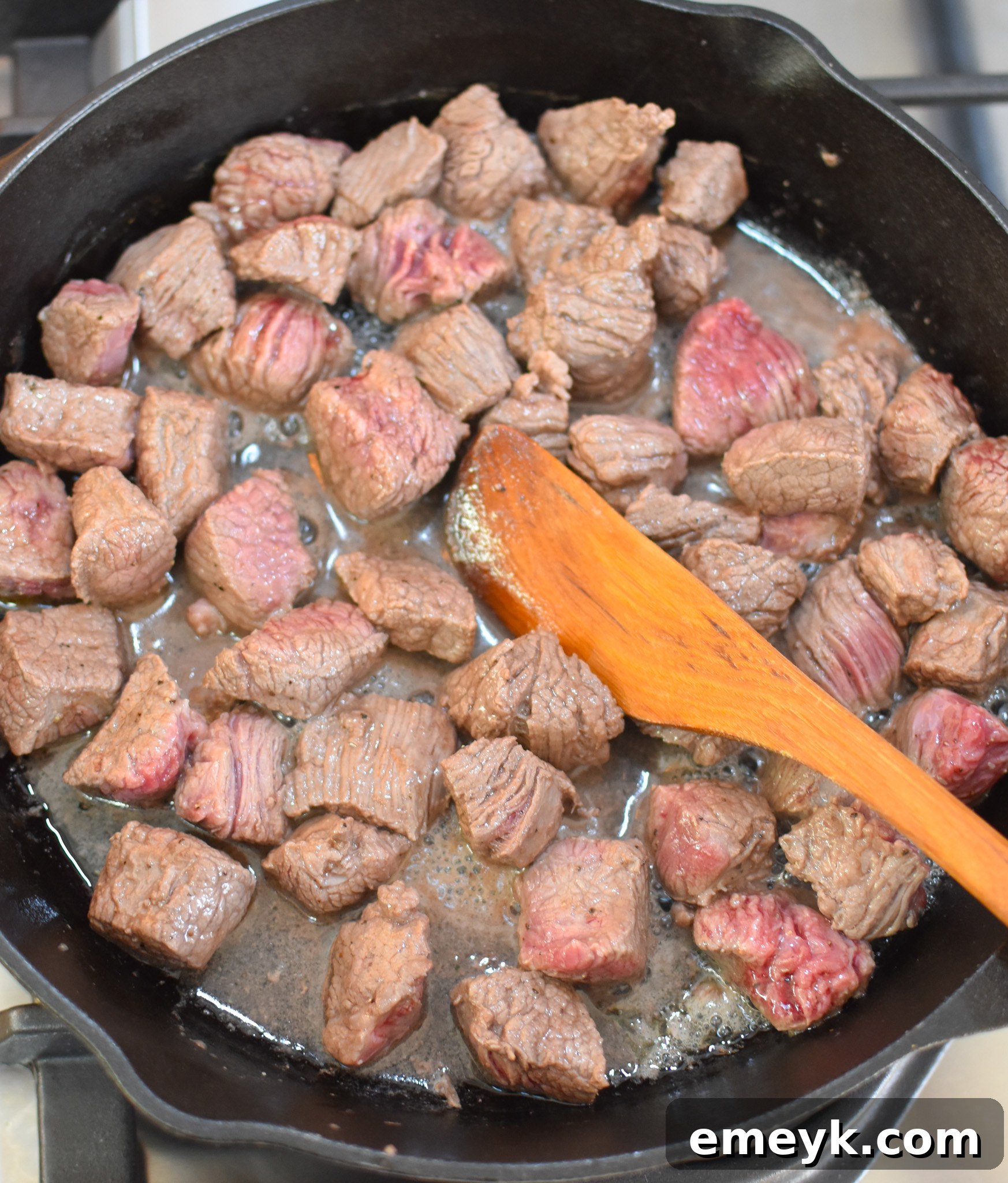 Close-up of beef chuck roast browning in a skillet, creating a rich, flavorful crust before being added to the slow cooker.