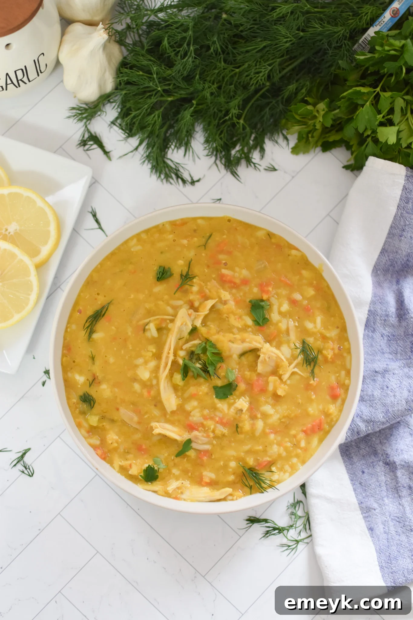 A serving of Chicken Lentil Soup in a white bowl, garnished with fresh parsley.
