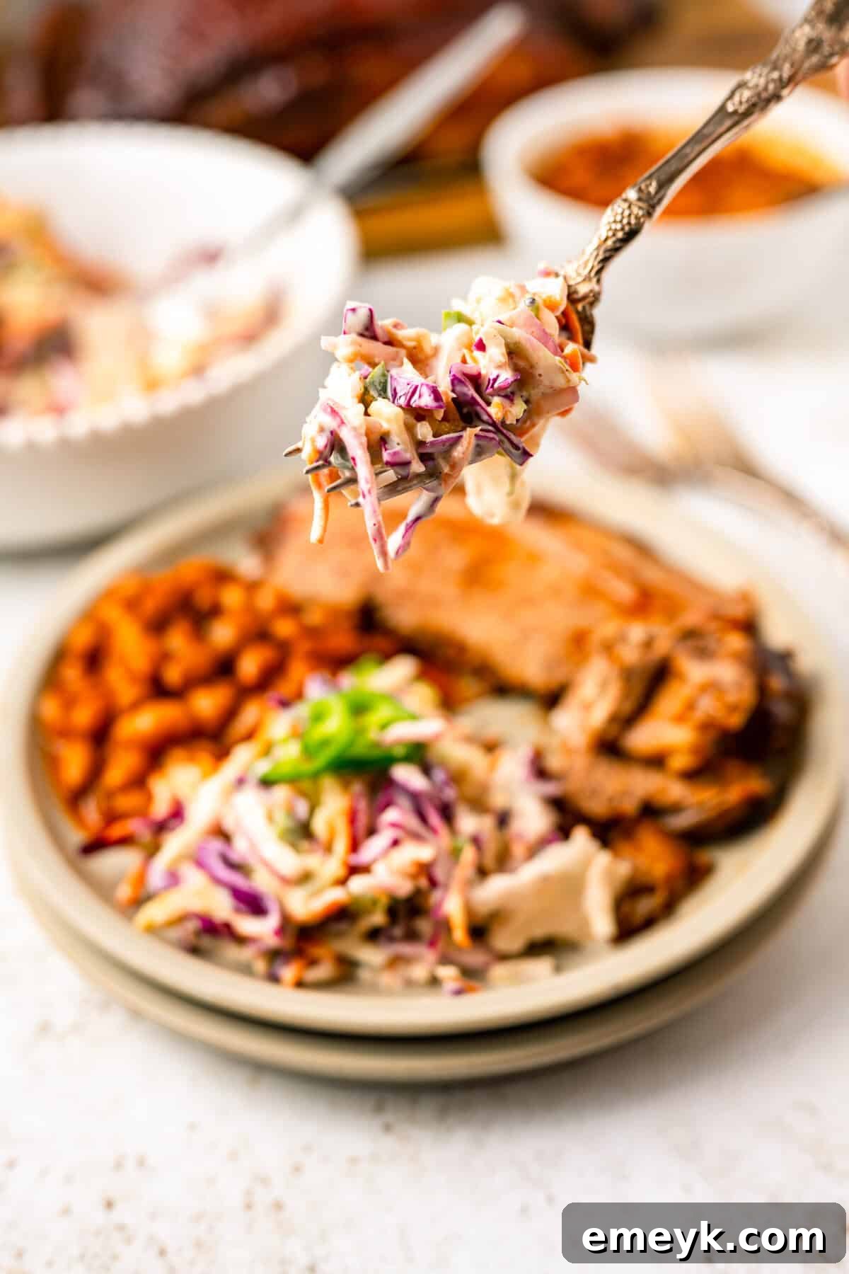 Kickin Jalapeno Coleslaw 10 A serving of vibrant Jalapeño Coleslaw on a plate next to other dishes, showcasing its role as a perfect accompaniment.