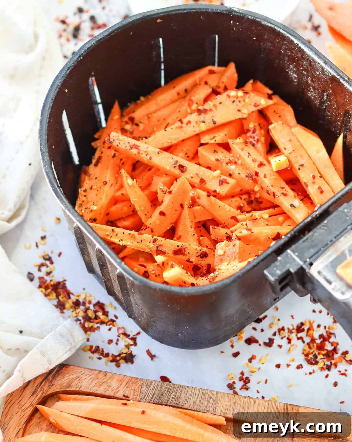 Air Fryer Sweet Potato Fries in an air fryer basket, ready to be cooked
