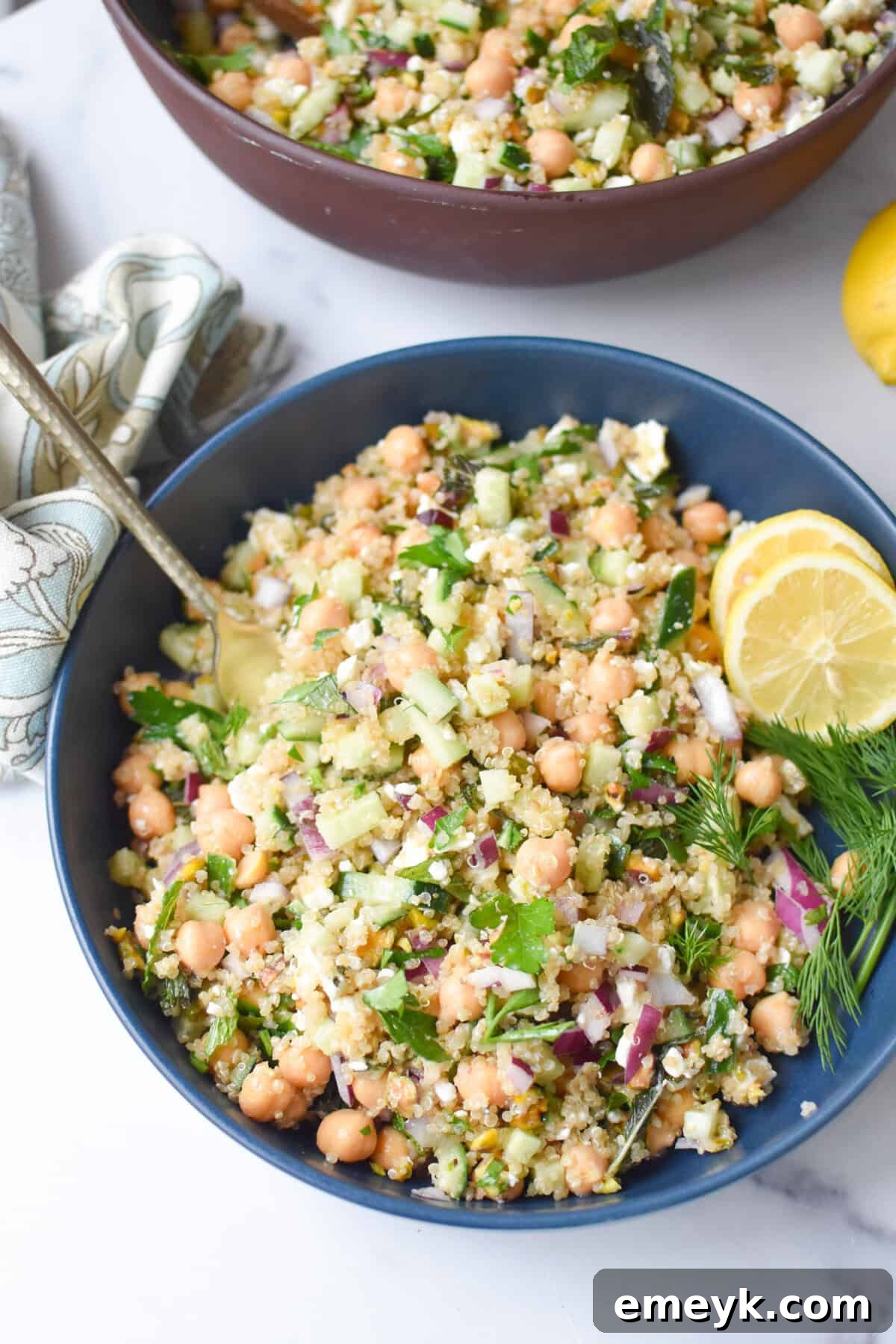 The Secret to Jennifer Aniston's Viral Salad Sensation 7 a Jennifer aniston salad in a blue mixing bowl with lemon wheels and fresh dill.