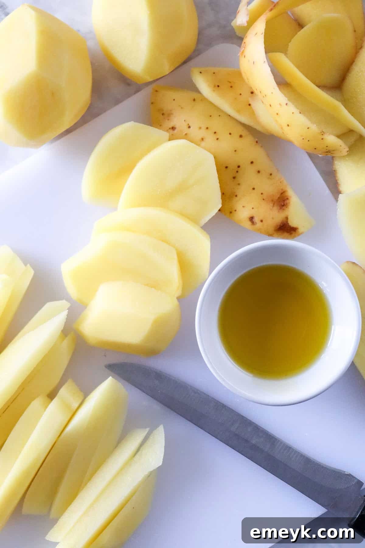Potatoes being carefully cut into evenly sized strips for french fries