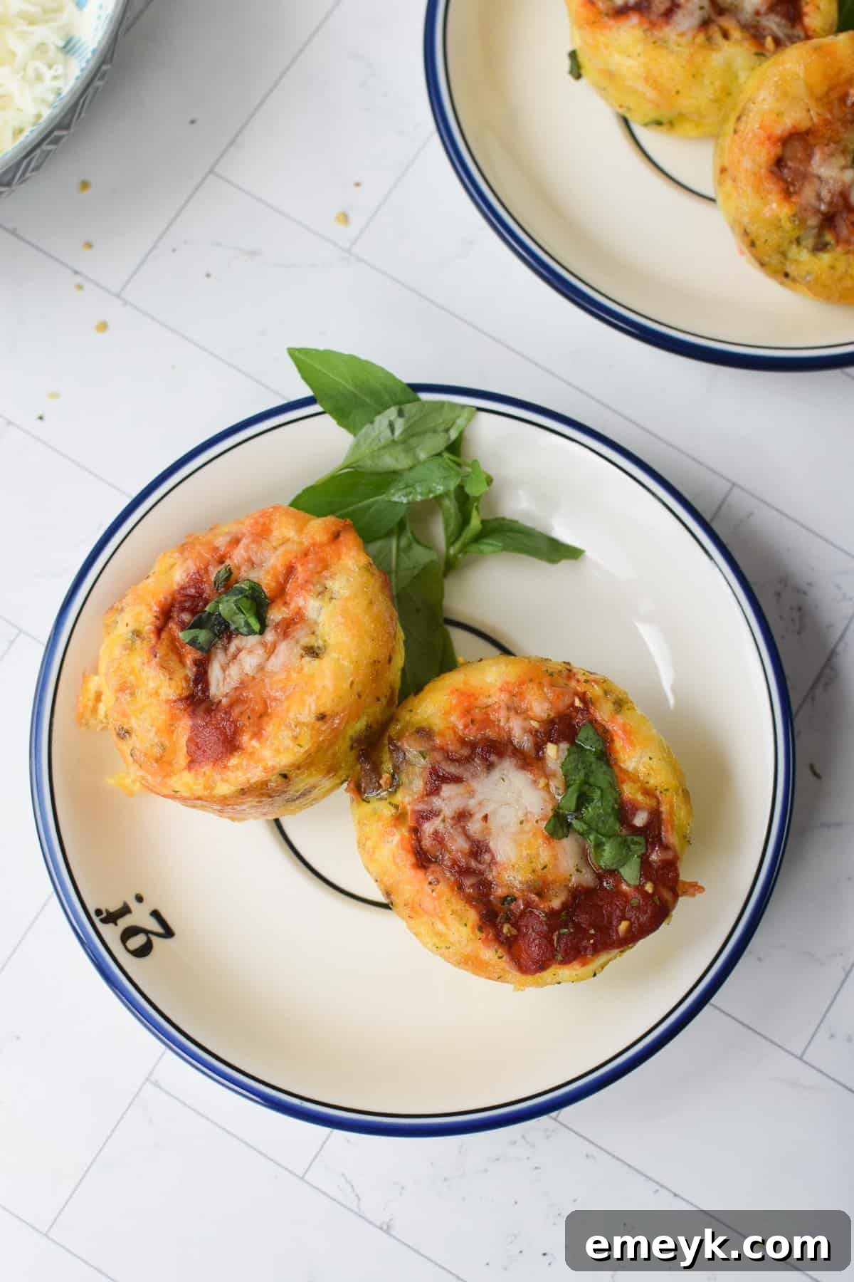 A selection of baked Pizza Egg Muffins arranged on a round white plate, ready to be served