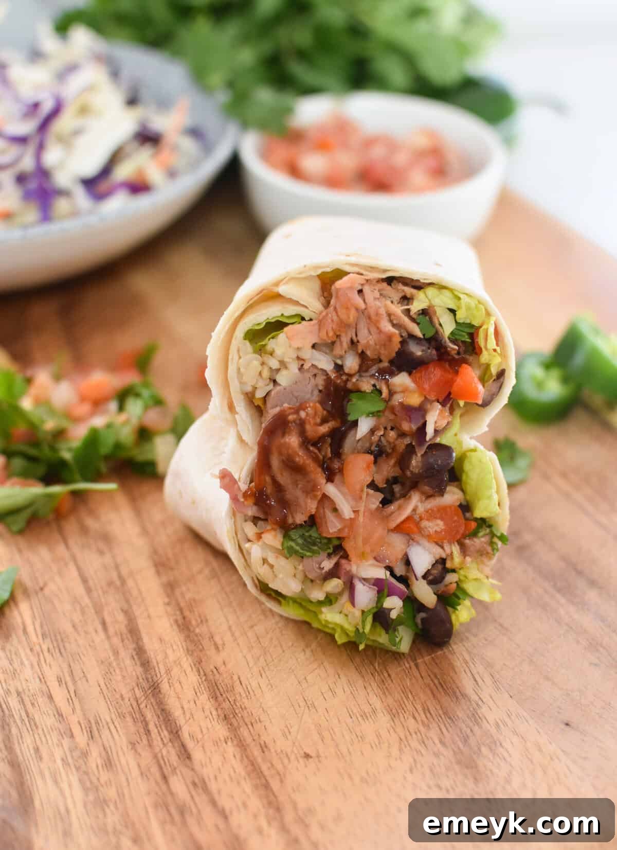 Smoked Pork Burrito Sensations 3 Two perfectly rolled Pulled Pork Burritos artfully arranged on a rustic wooden cutting board