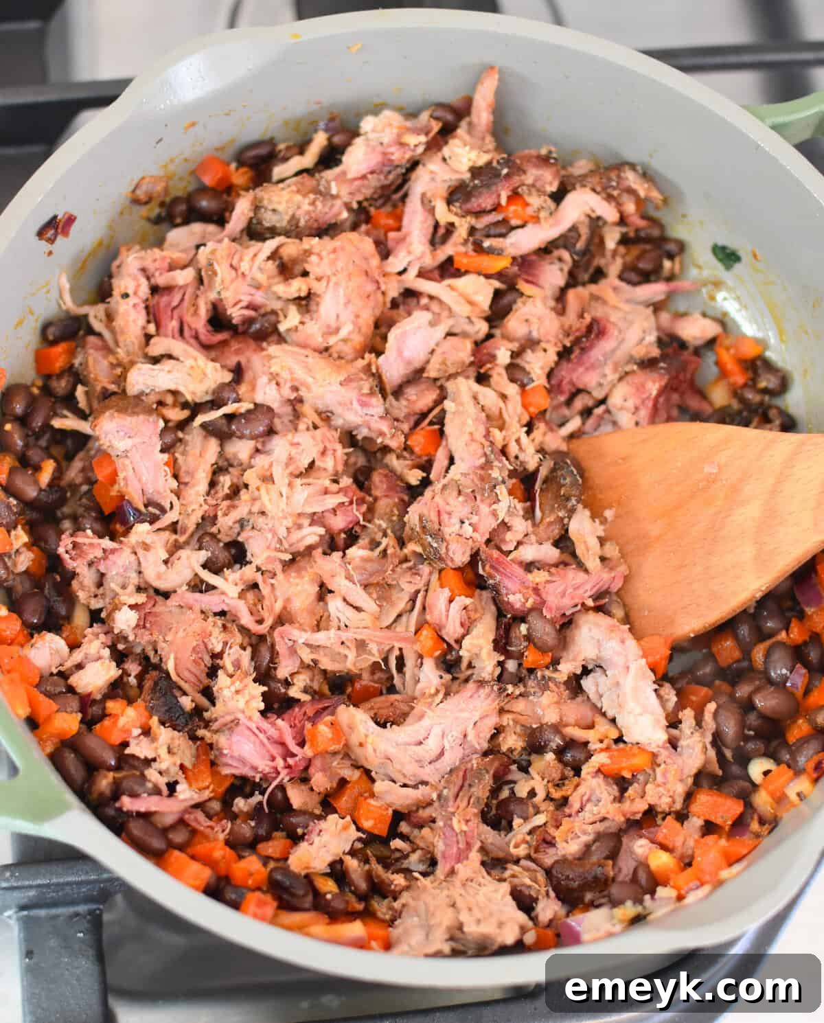 Smoked Pork Burrito Sensations 7 Close-up of sautéed pulled pork, black beans, and diced red peppers in a skillet, steaming hot and ready