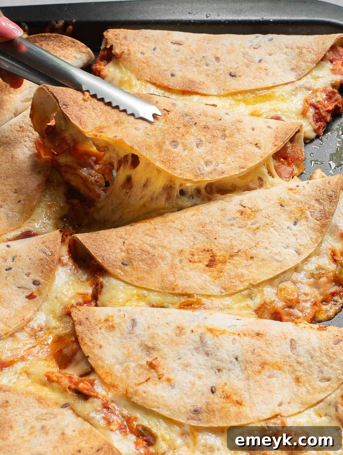 Baked Chicken Tacos being served with tongs, showcasing their crispy texture