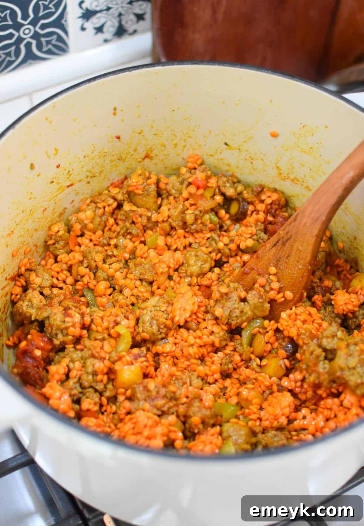 Lentil Sausage Soup garnished with fresh herbs in a white bowl
