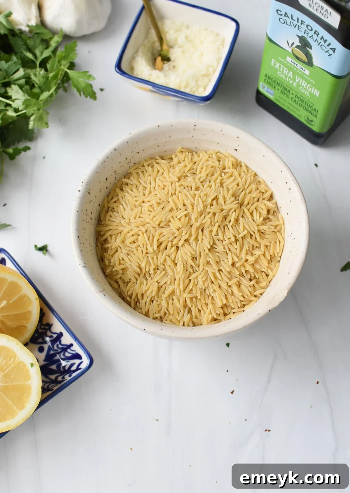 Fresh ingredients for Lemon Orzo including orzo pasta, lemons, garlic, and fresh herbs.