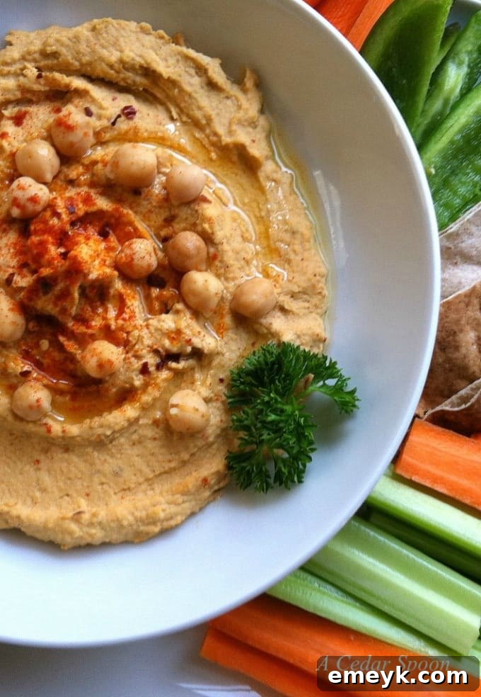 A vibrant bowl of spicy hummus garnished with fresh parsley, ready to be served