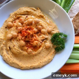 Spicy Hummus with parsley garnish in a white bowl