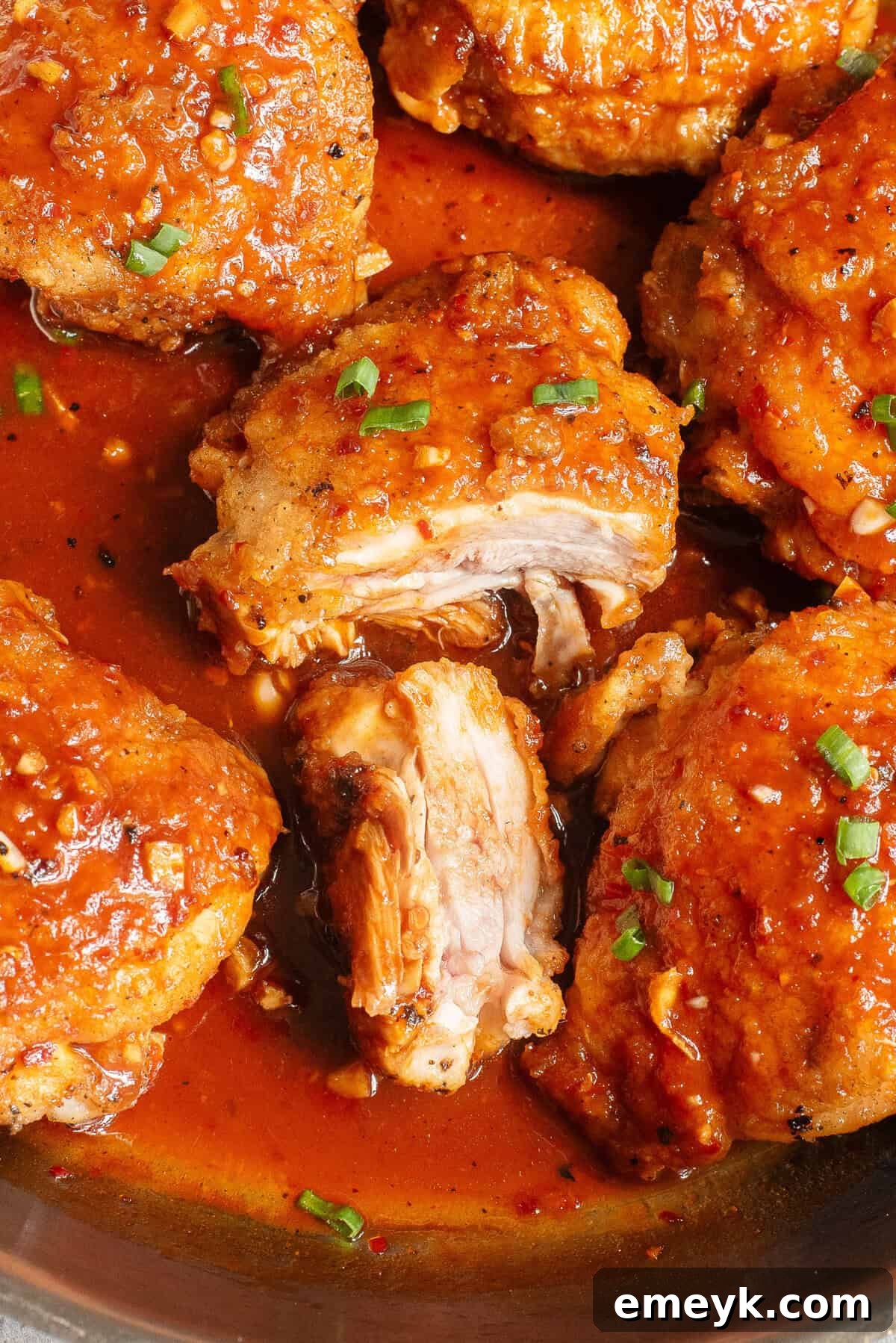 A perfectly cooked Honey Ginger Chicken thigh, sliced to reveal tender, juicy meat.