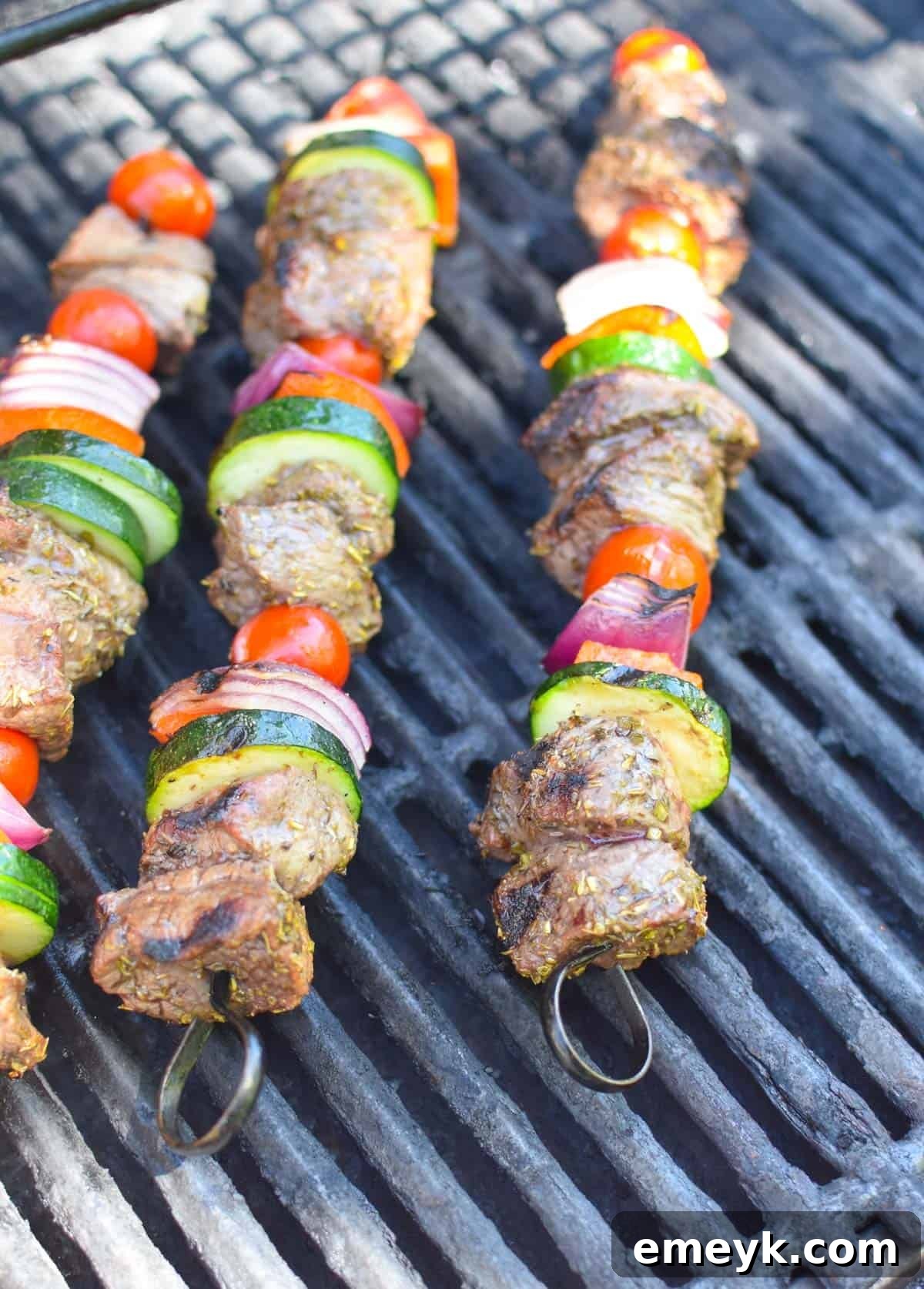 Beef Souvlaki skewers cooking on a hot grill, showing visible grill marks and smoky sizzle.