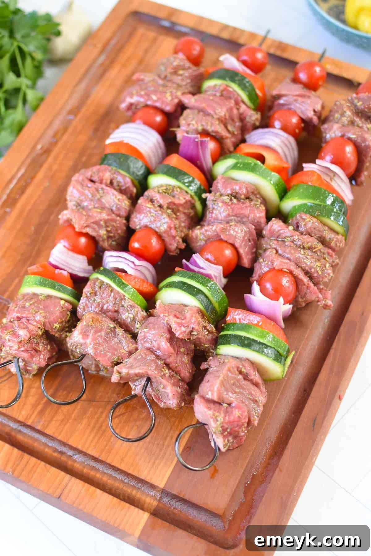 Assembled Beef Souvlaki skewers, ready for grilling, arranged neatly on a cutting board.