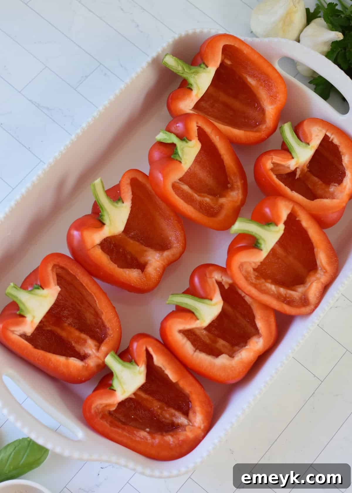 Bell pepper halves without seeds in a baking dish, ready for grilling.