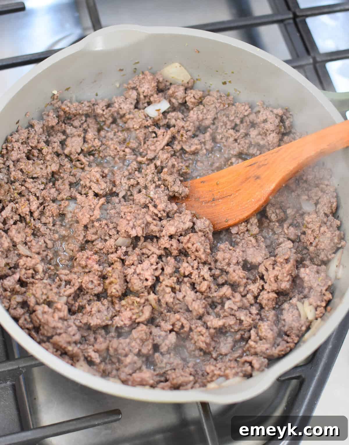 Ground beef mixture with diced tomatoes and spices simmering in a skillet.