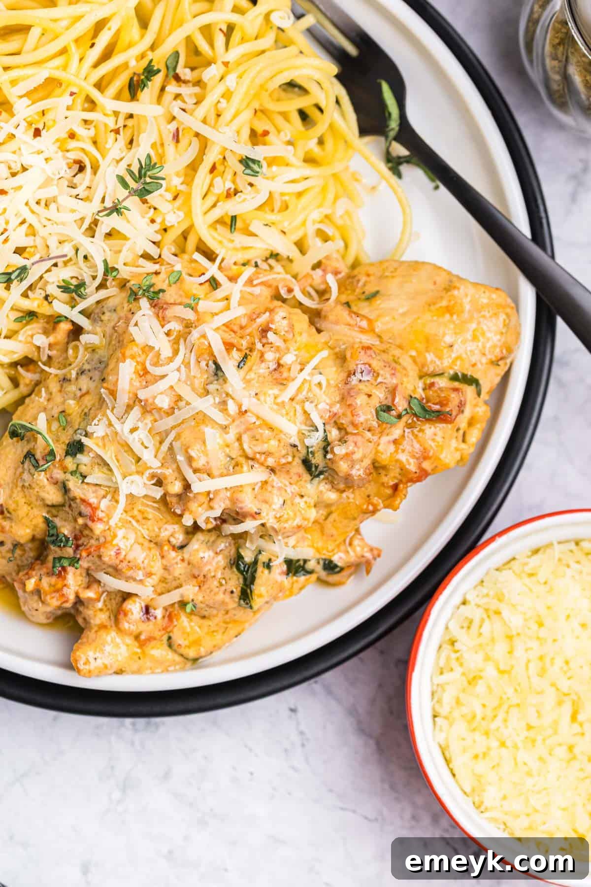 A beautifully plated Marry Me Chicken dish, showcasing tender chicken breasts in a creamy sun-dried tomato and Parmesan sauce, garnished with fresh basil.