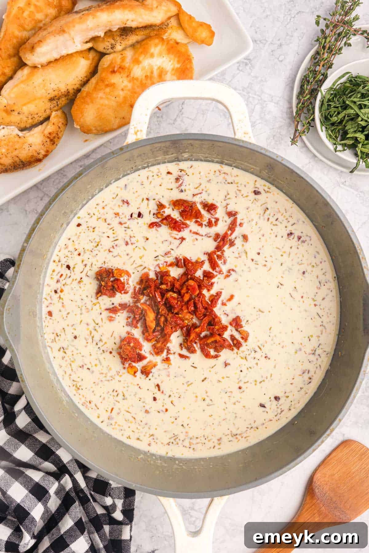The creamy Marry Me Chicken sauce simmering in a skillet, rich with sun-dried tomatoes and Parmesan.