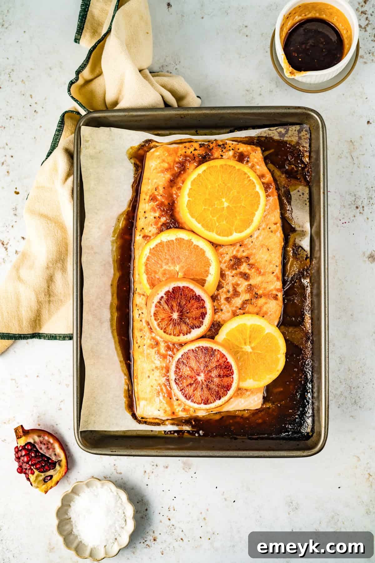 Baked Orange Glazed Salmon, fresh out of the oven, showing its golden-brown glaze and tender texture on a baking sheet.