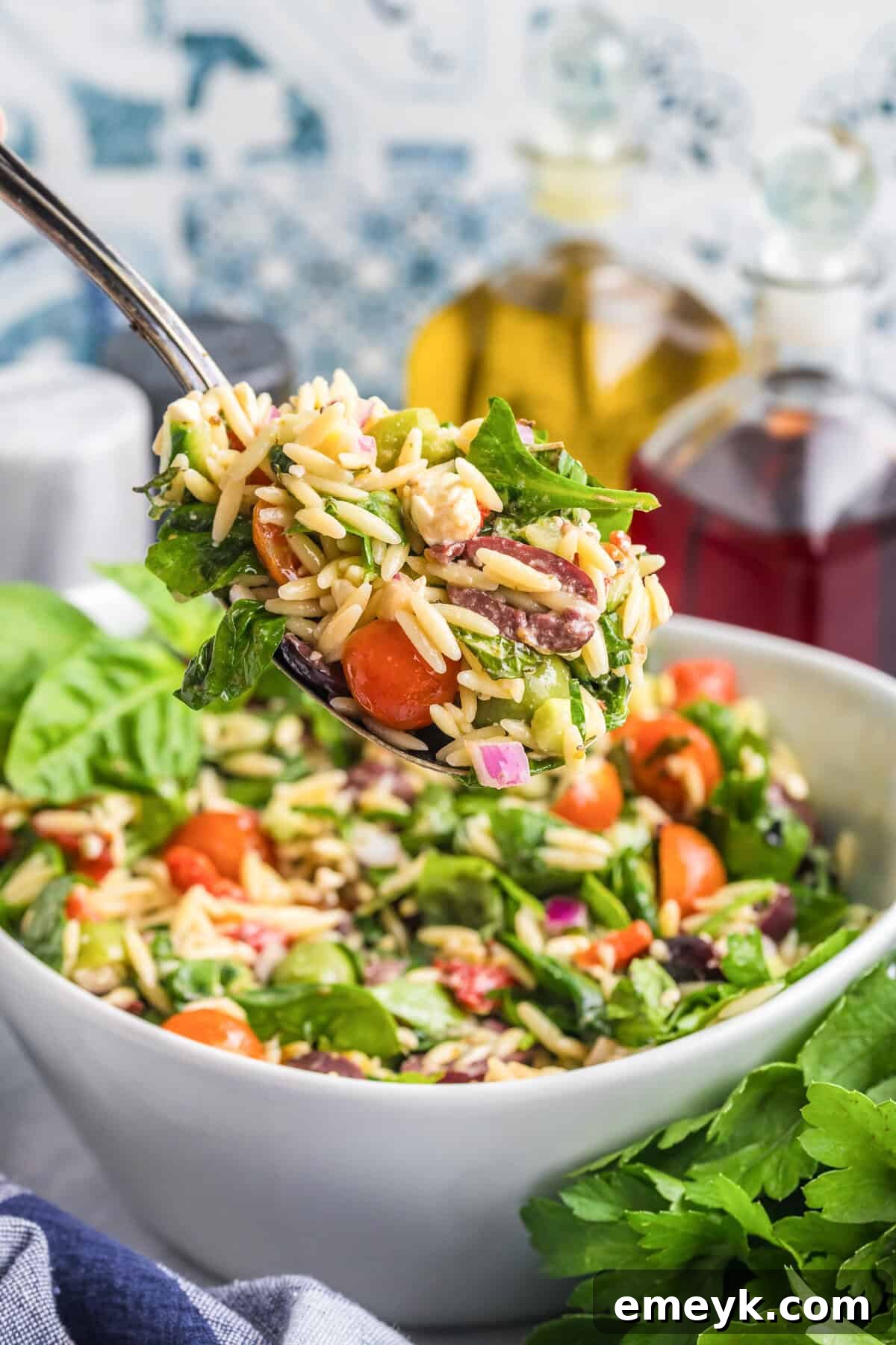 Mediterranean Pasta Salad with a large serving spoon