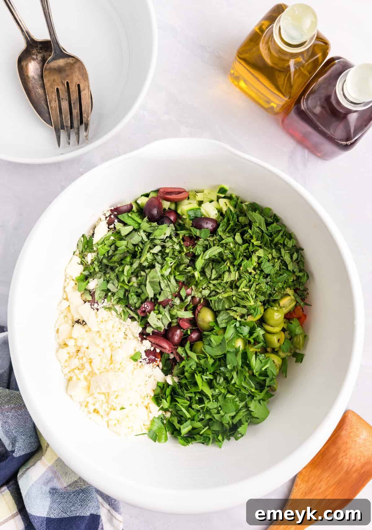 Raw ingredients being mixed for Mediterranean Pasta Salad