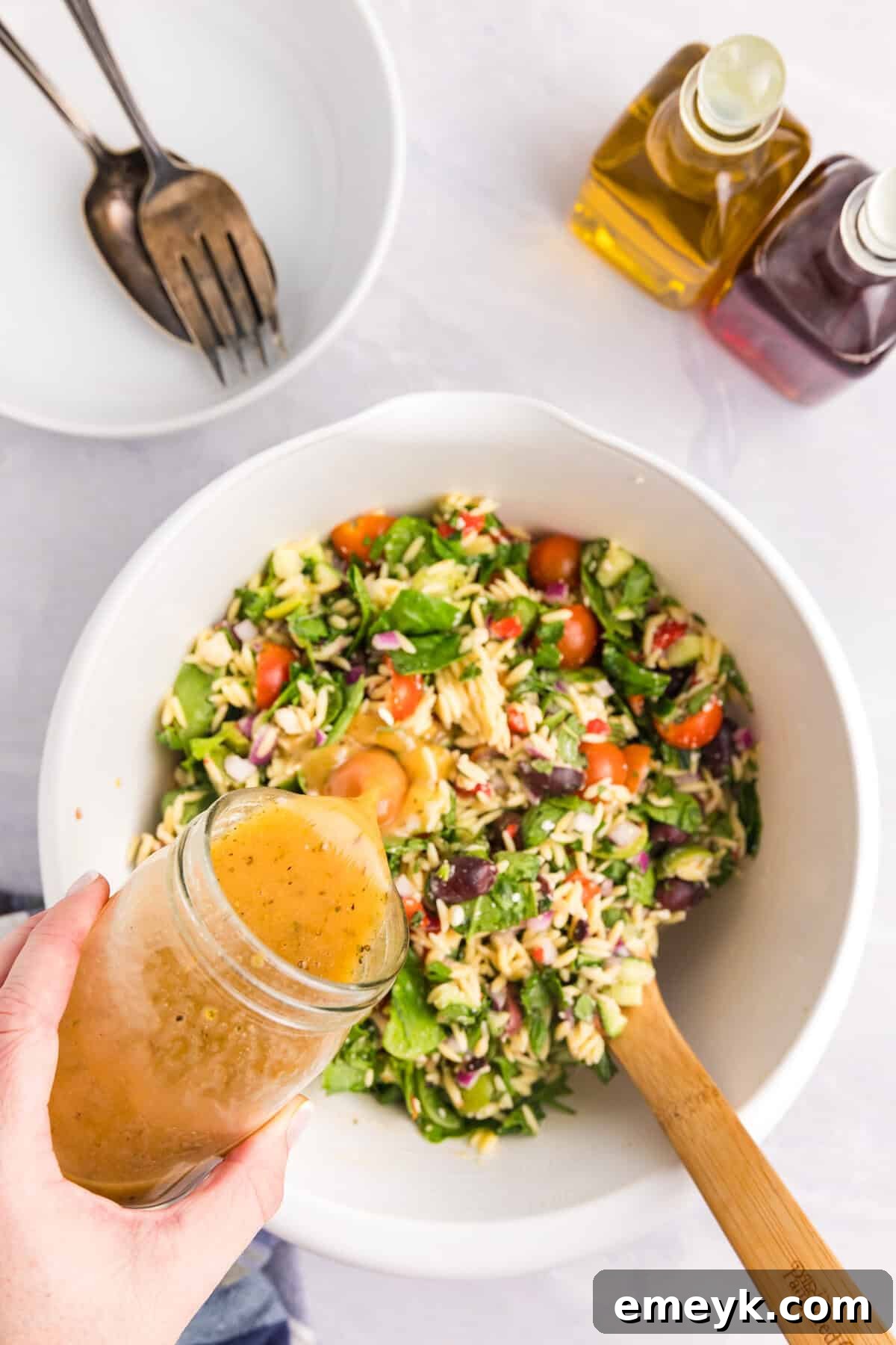 Greek dressing being poured over the Mediterranean Pasta Salad