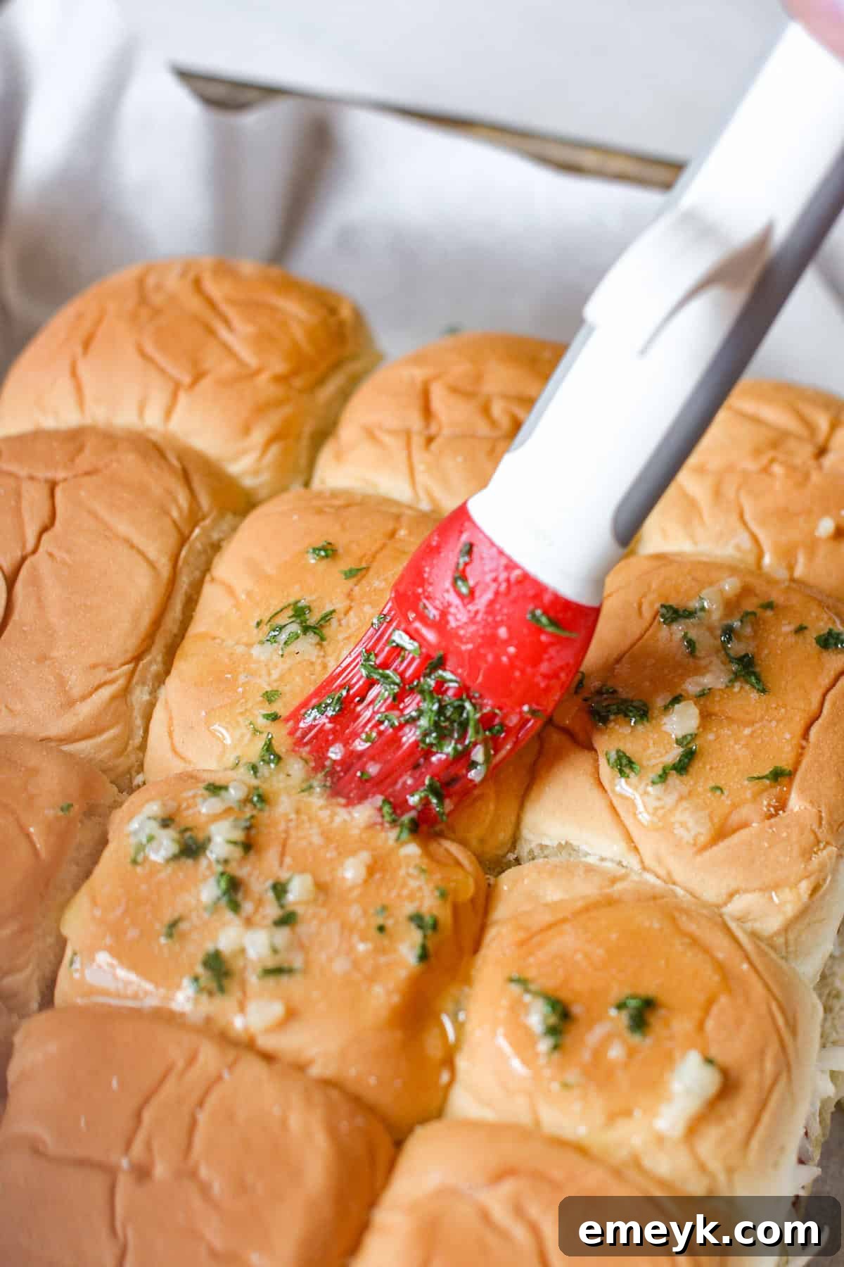 Garlic butter brushed onto the top Hawaiian rolls for sliders