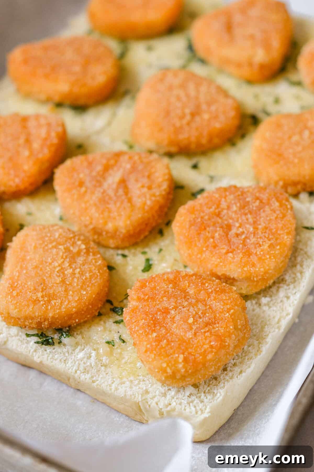 Chicken nuggets placed on Hawaiian rolls for sliders