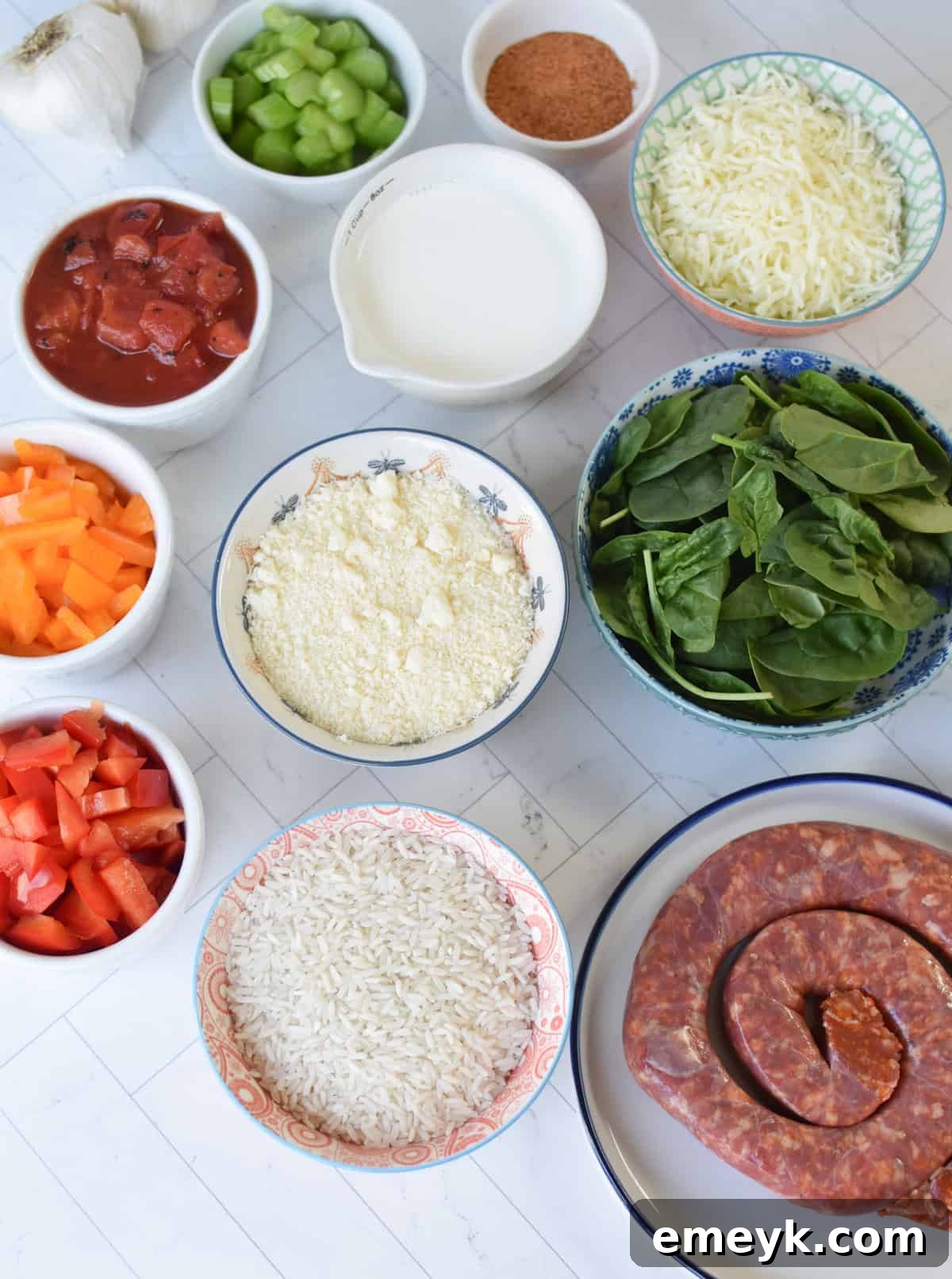 Various ingredients for Creamy Cajun Sausage Rice Skillet laid out