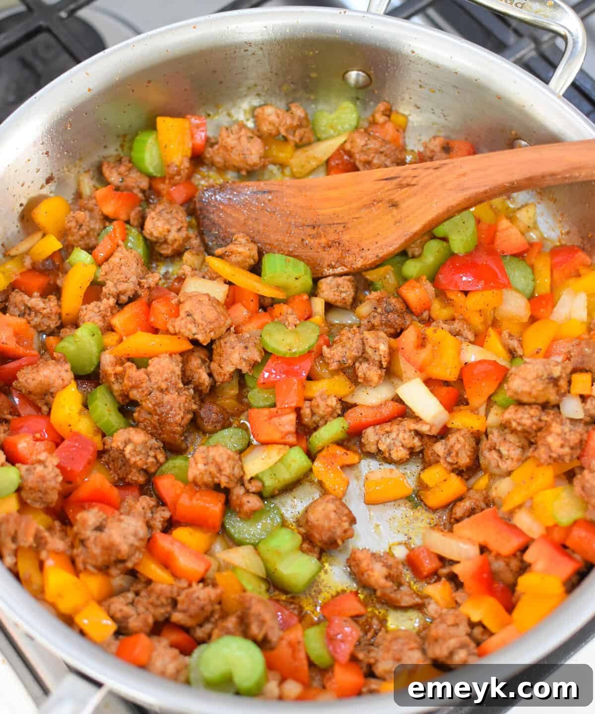 Cooked sausage and sautéed vegetables in a skillet for Creamy Cajun Sausage Rice Skillet