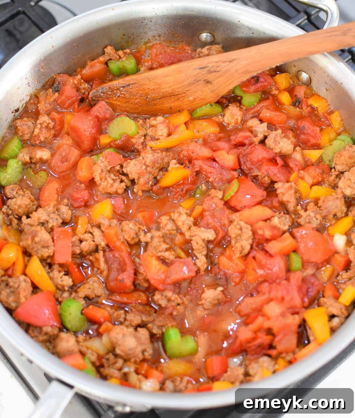 Diced tomatoes added to the skillet with sausage and vegetables for the Creamy Cajun Sausage Rice Skillet
