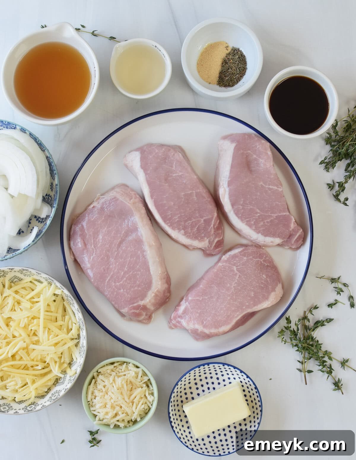 French Onion Smothered Pork Chops 4 Assorted fresh ingredients for French Onion Pork Chops arranged on a wooden board