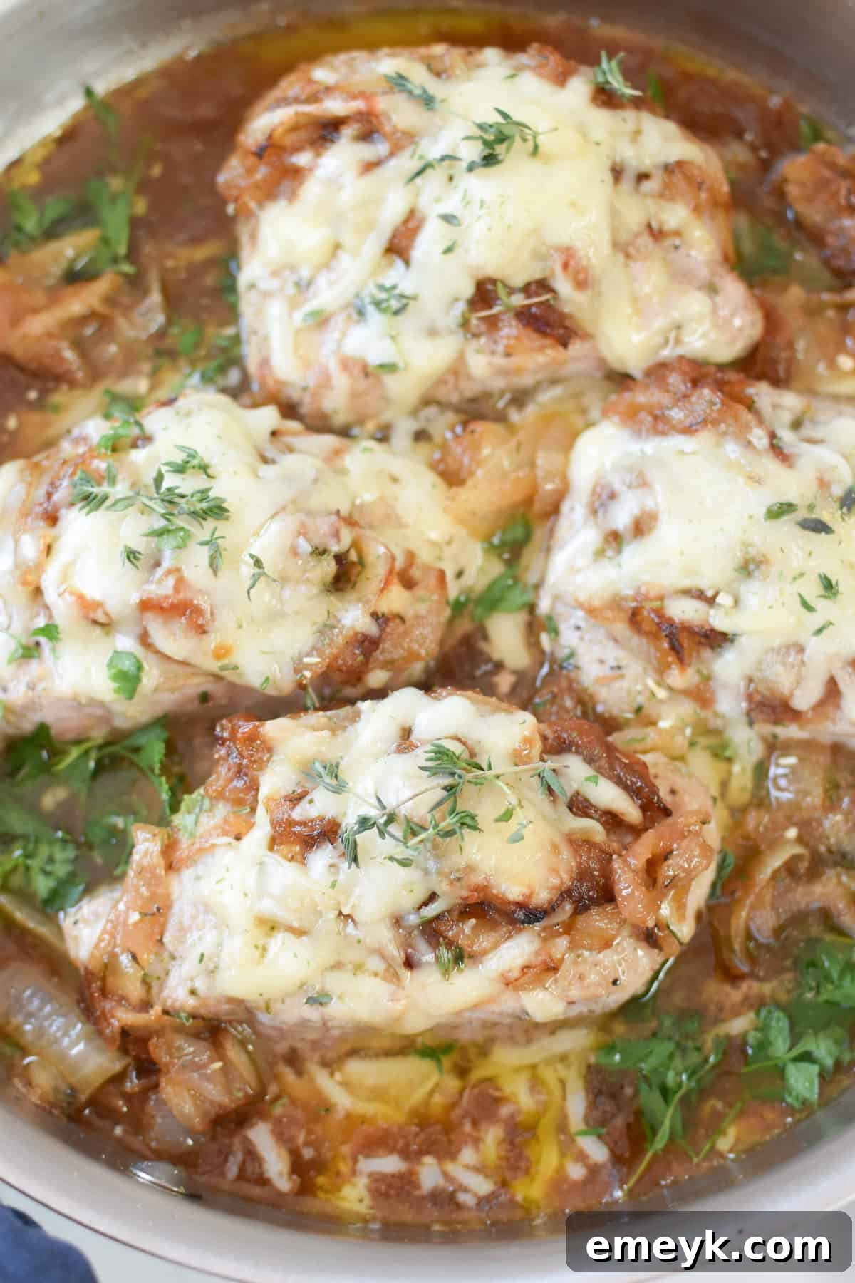 French Onion Smothered Pork Chops 8 French Onion Pork Chops meticulously garnished with vibrant fresh thyme sprigs