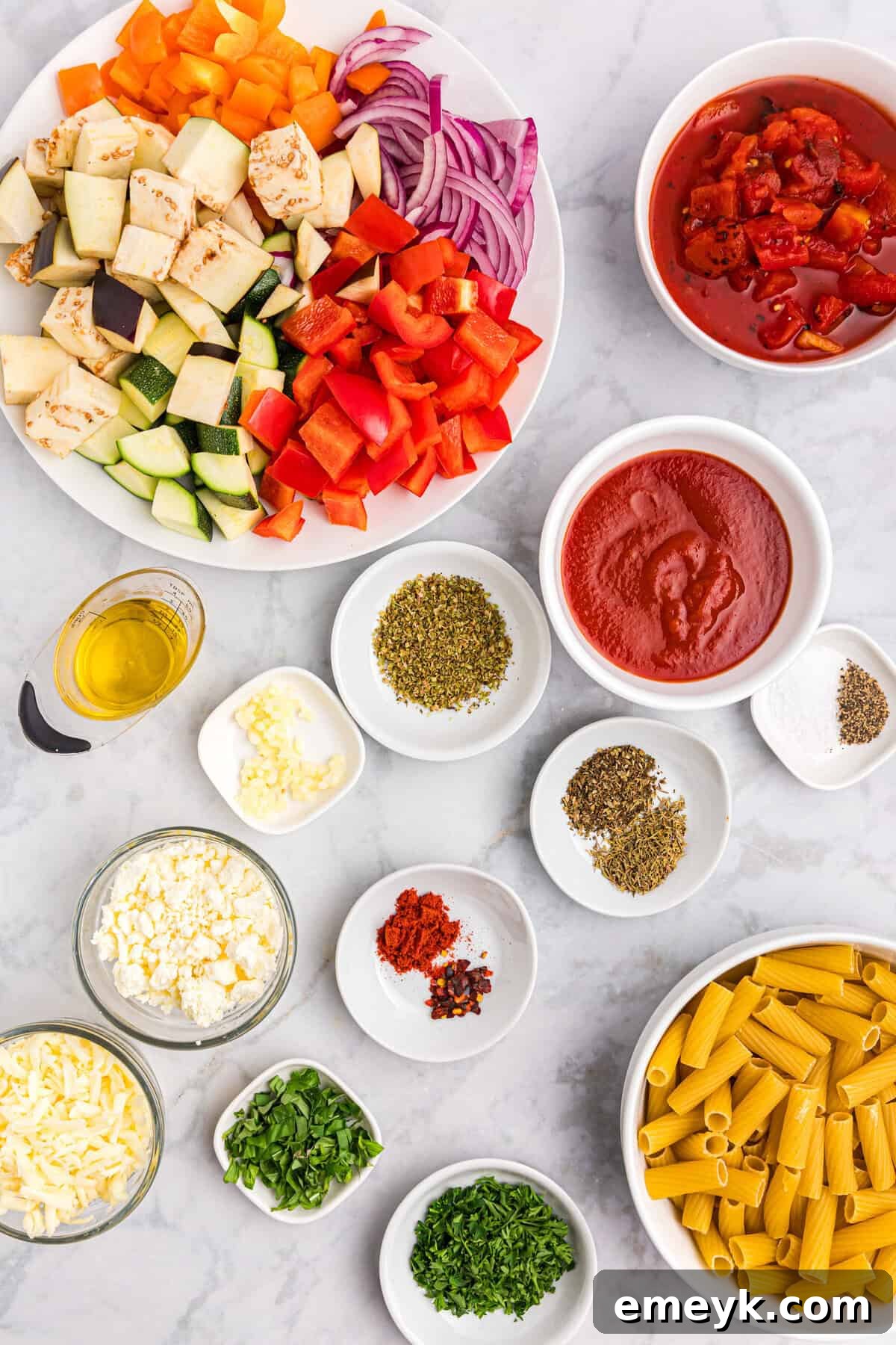 Mediterranean Harvest Roasted Pasta Bake 3 Fresh ingredients laid out for Mediterranean Roasted Vegetable Pasta Bake, including various vegetables, spices, pasta, and cheese