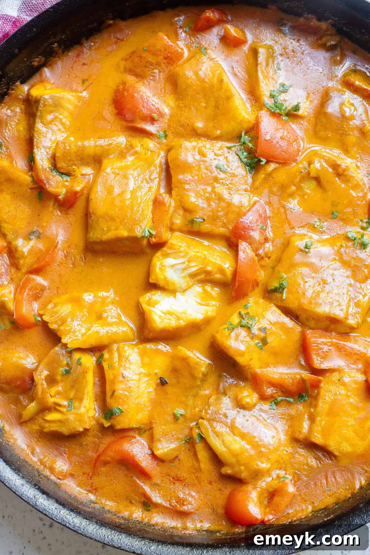 Coconut Fish Curry simmering in a large skillet, close-up