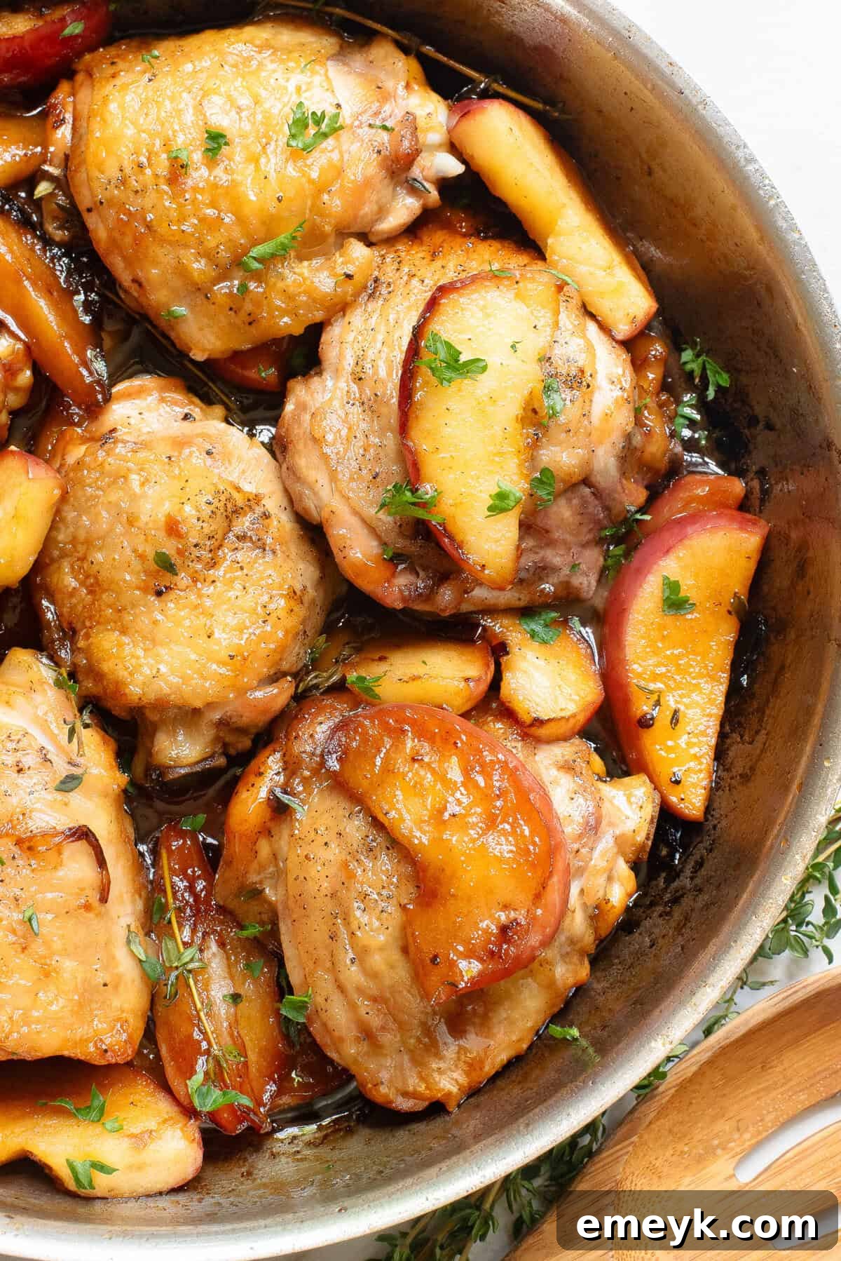 Skillet Apple Cider Chicken in a rustic cast iron skillet, garnished with fresh herbs.
