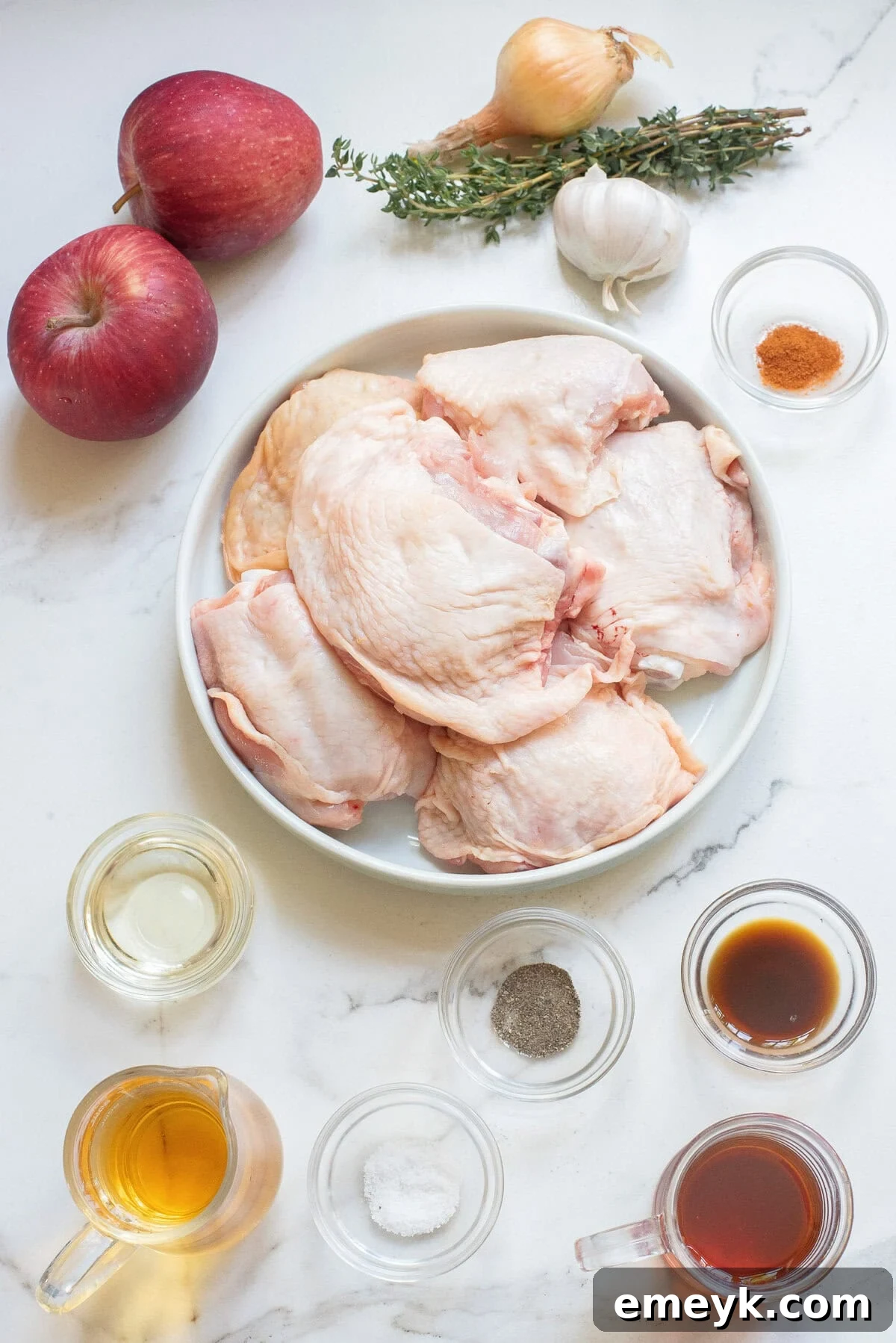 All ingredients for Skillet Apple Cider Chicken laid out, including chicken, apples, spices, and sauces.