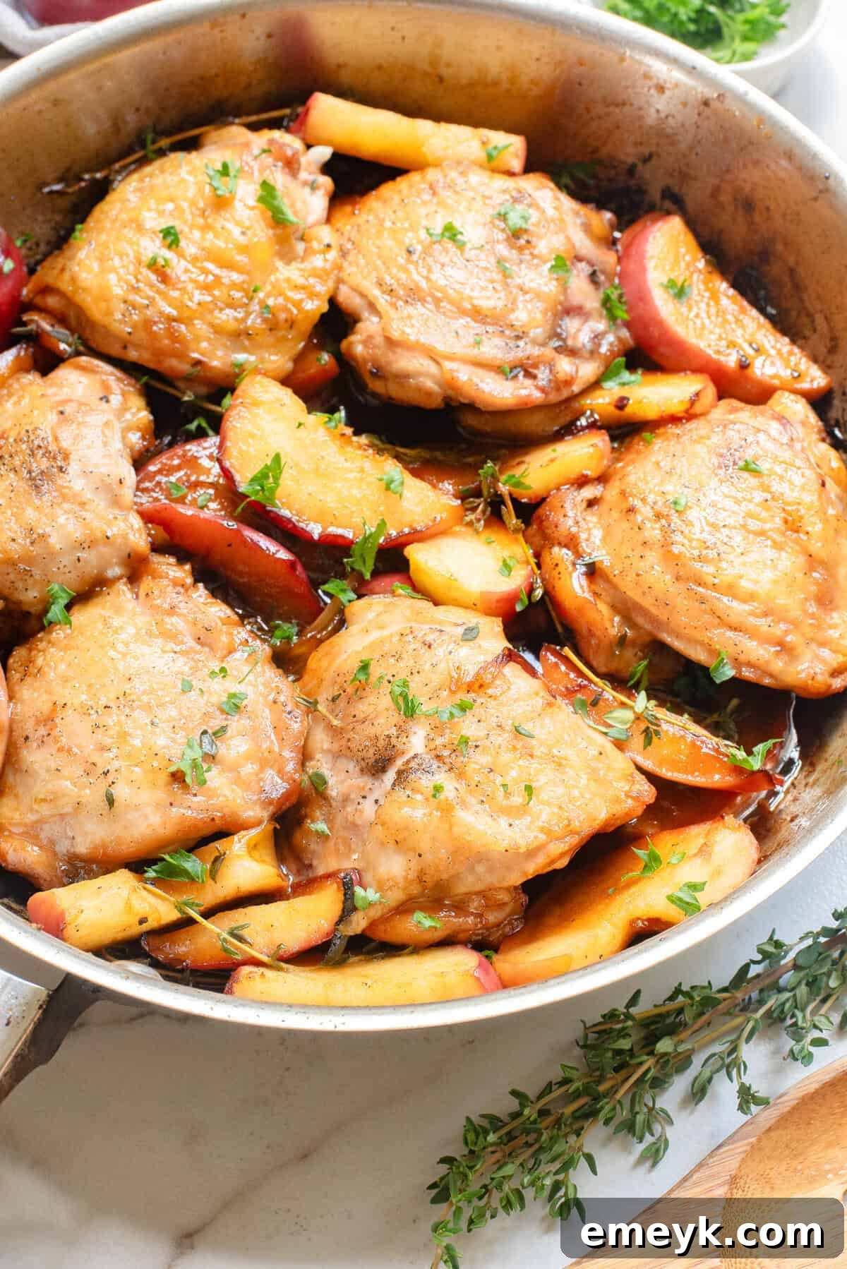 Skillet Apple Cider Chicken garnished with fresh thyme, emphasizing its autumn theme.