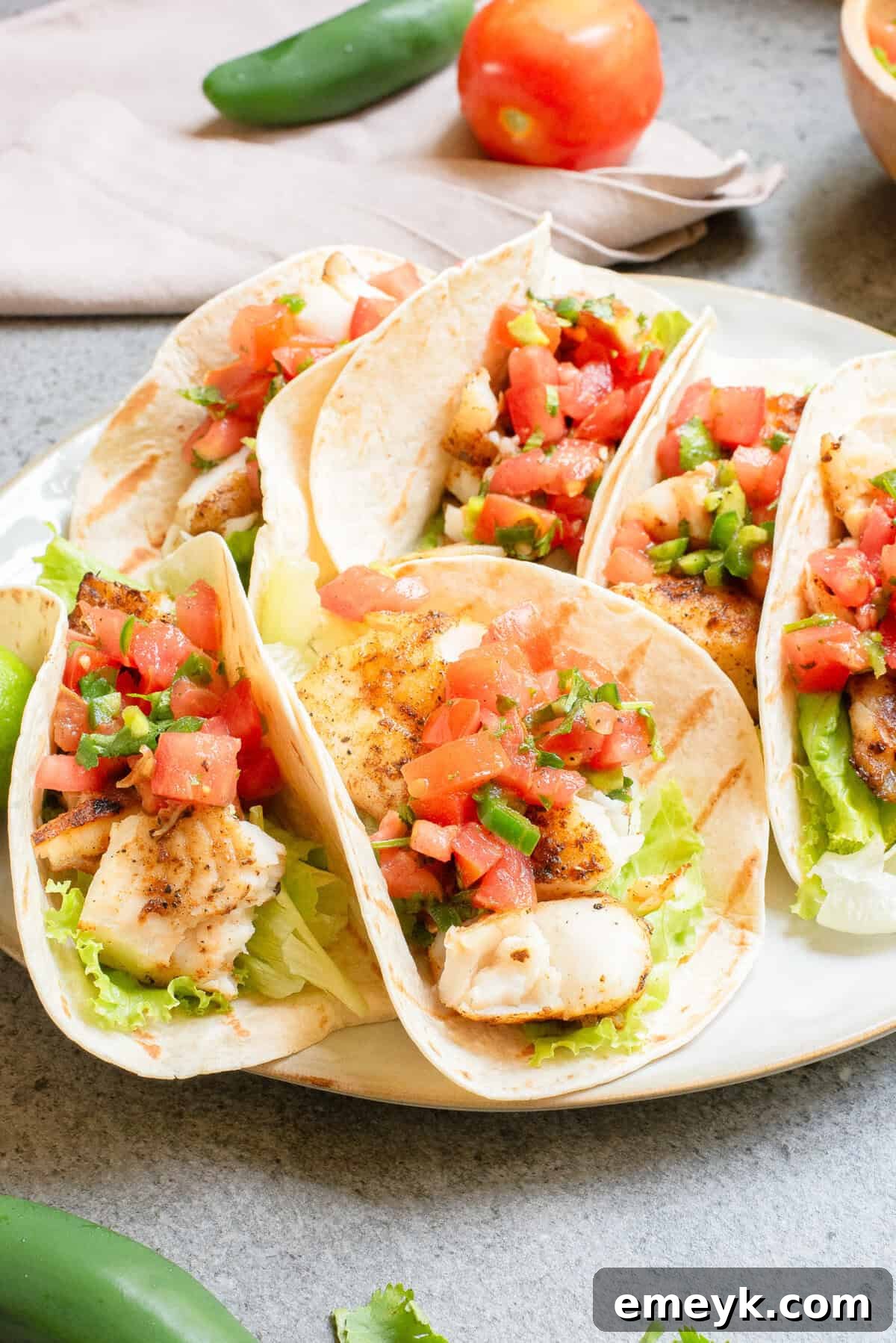 Cajun Blackened Fish Tacos 12 Close-up of Blackened Fish Tacos on a plate with fresh salsa and lime wedges