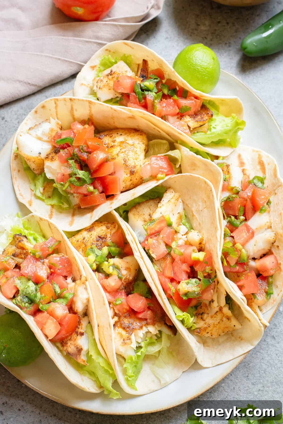 Two beautifully assembled Blackened Fish Tacos on a white plate
