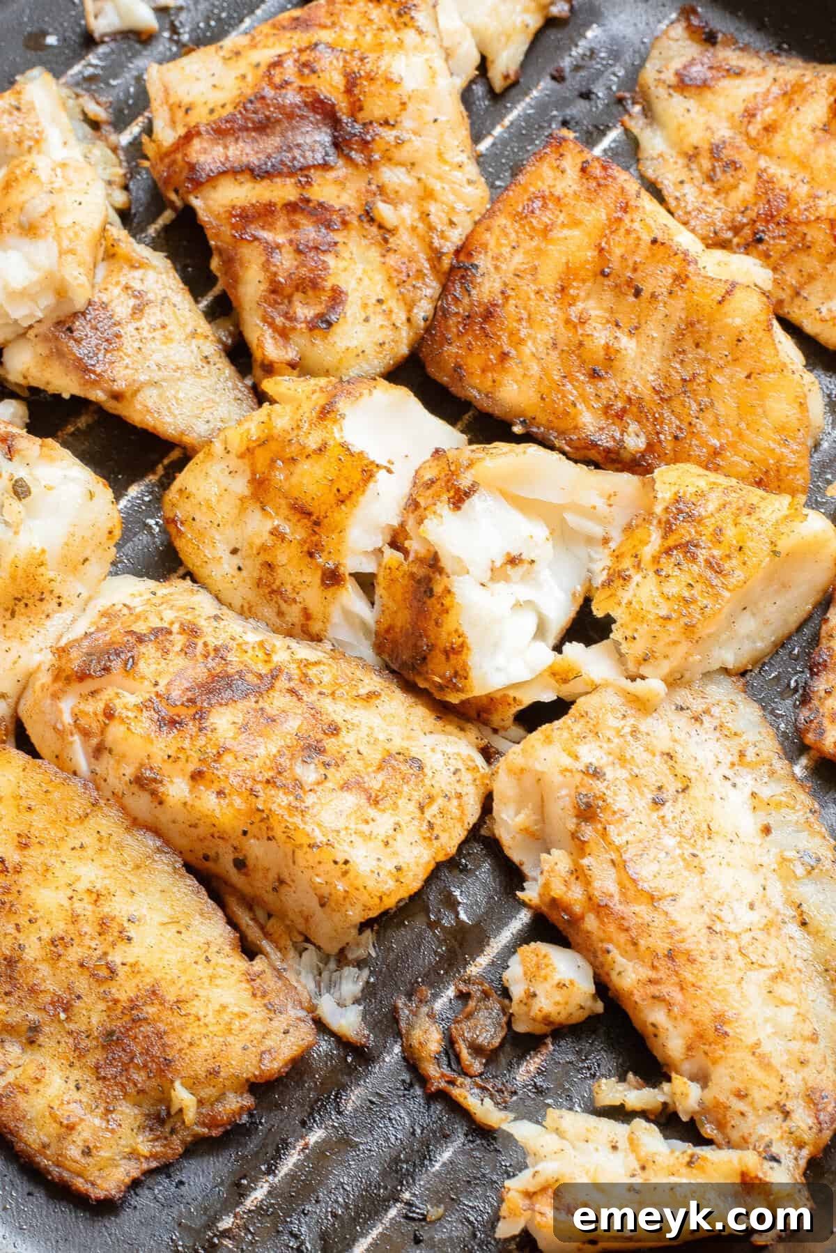 Blackened Fish Tacos sizzling in a cast iron skillet, showing the charred crust