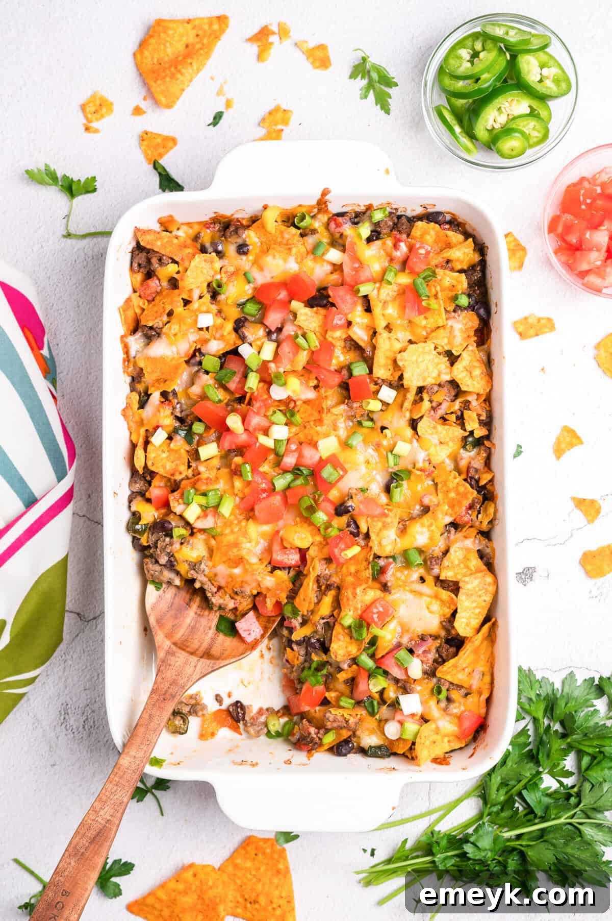 A serving spoon lifting a piece of Doritos Taco Casserole, showing the layers and melted cheese.
