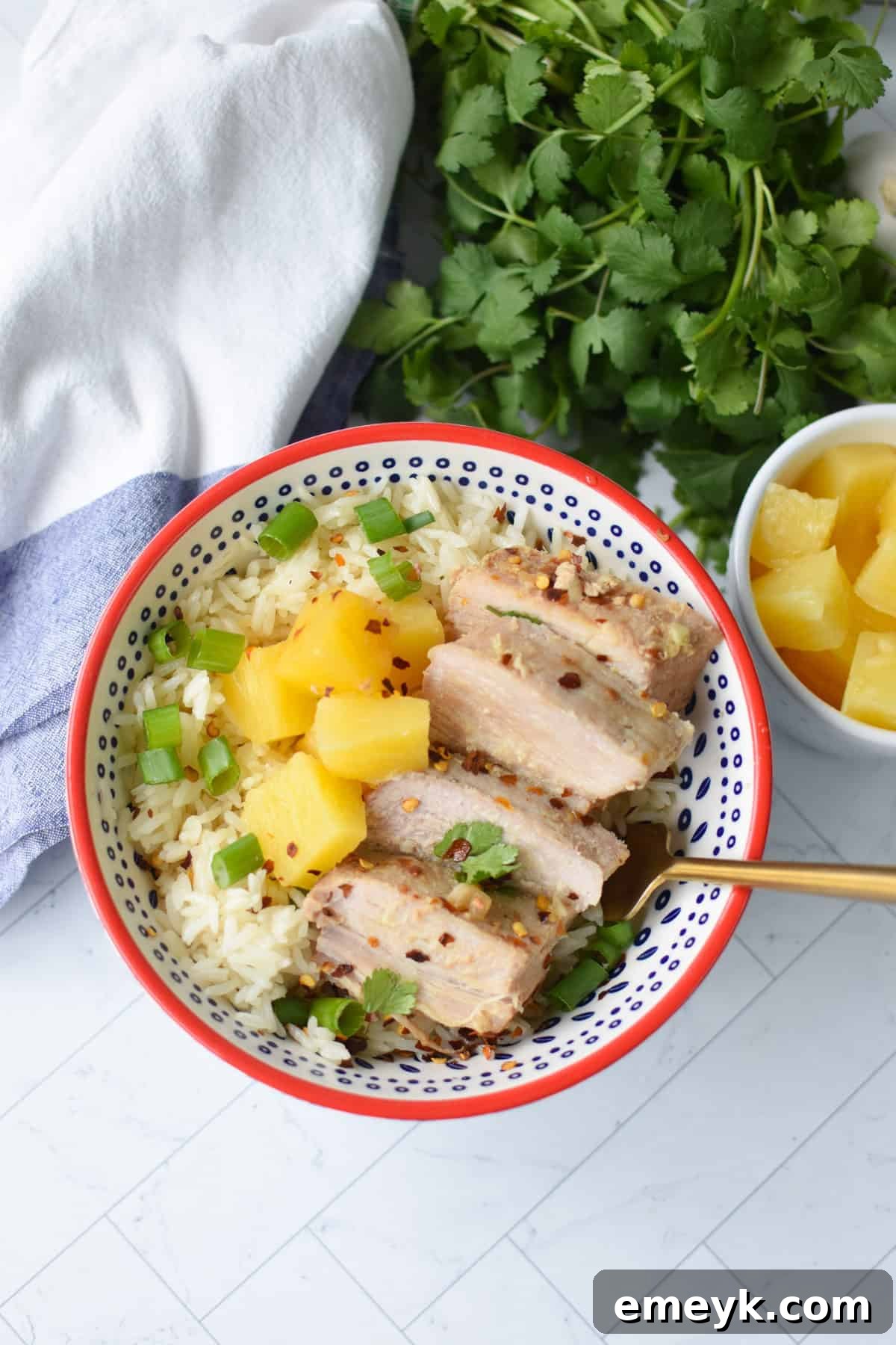 A close-up of a fork piercing a succulent slice of Slow Cooker Pineapple Pork Loin, showing its tenderness.