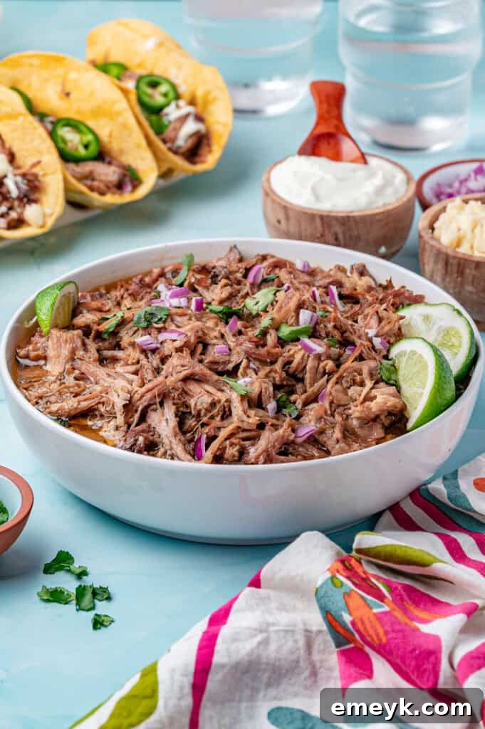 A large bowl brimming with Slow Cooker Pulled Pork, ready to be used in various Mexican dishes or served as is.