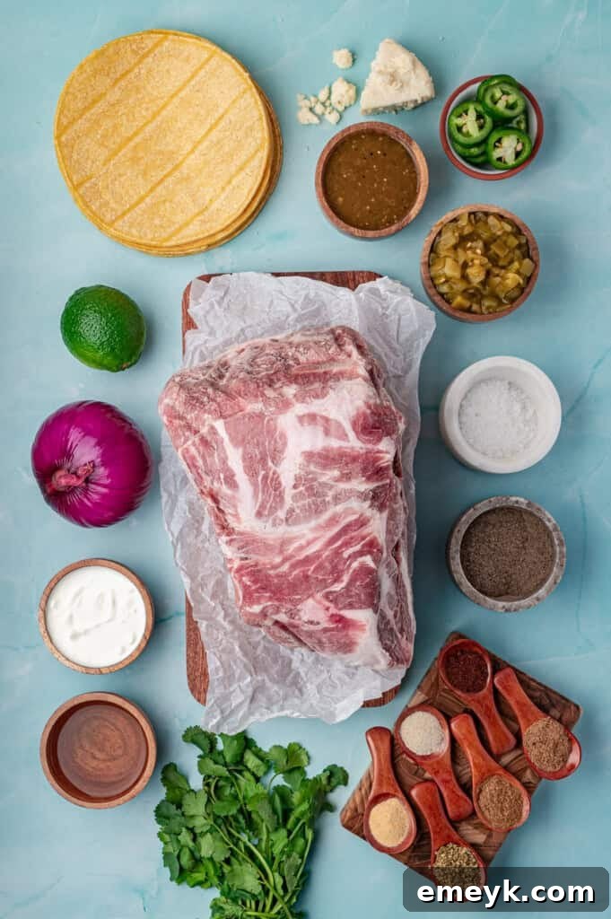 A flat lay image displaying all the fresh ingredients needed for Slow Cooker Pulled Pork Tacos: a pork shoulder, a bowl of spices, green chiles, salsa verde, and chicken broth, arranged on a rustic background.